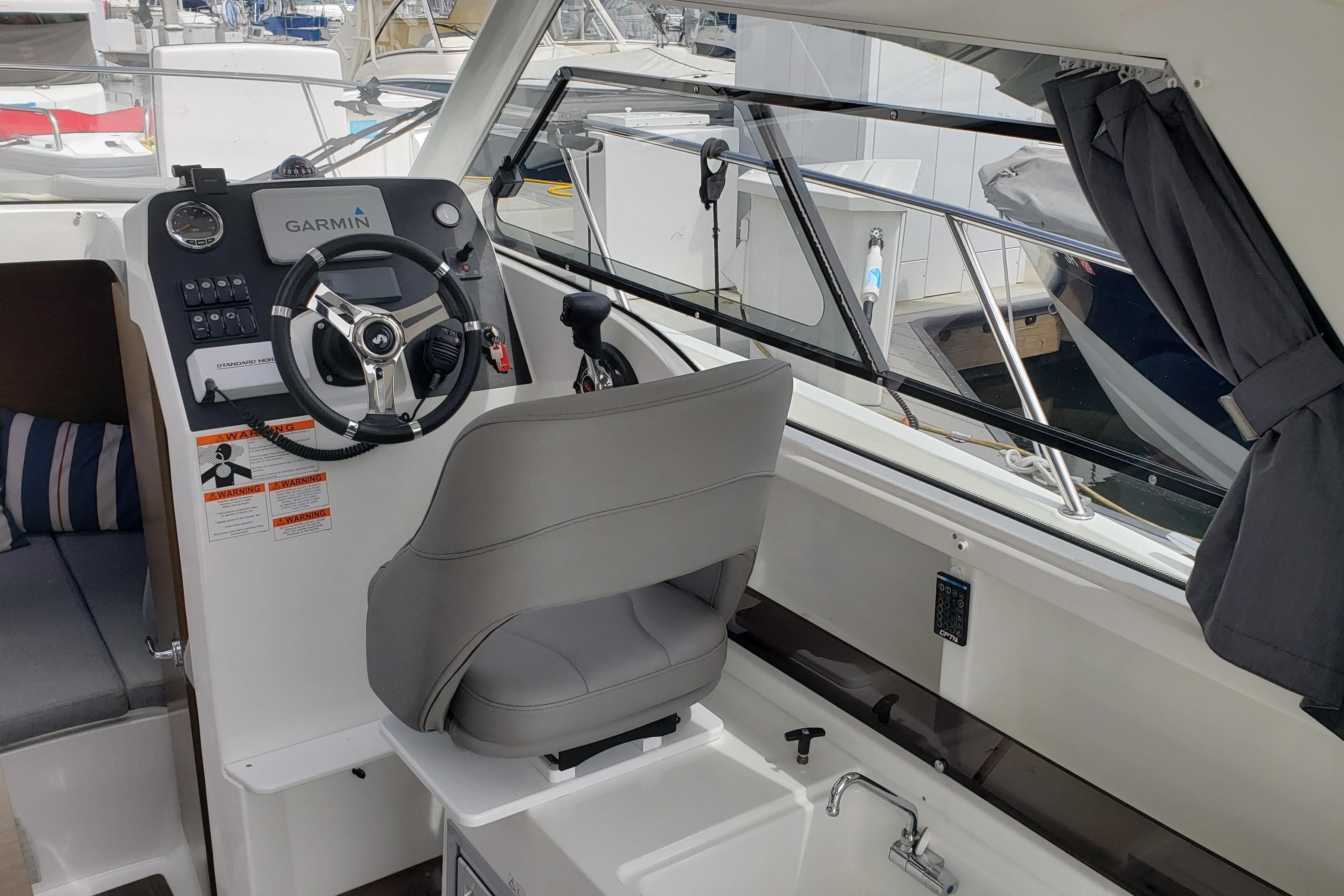 Interior cockpit of 2019 Beneteau Antares 23 with Garmin navigation system and comfortable seating.