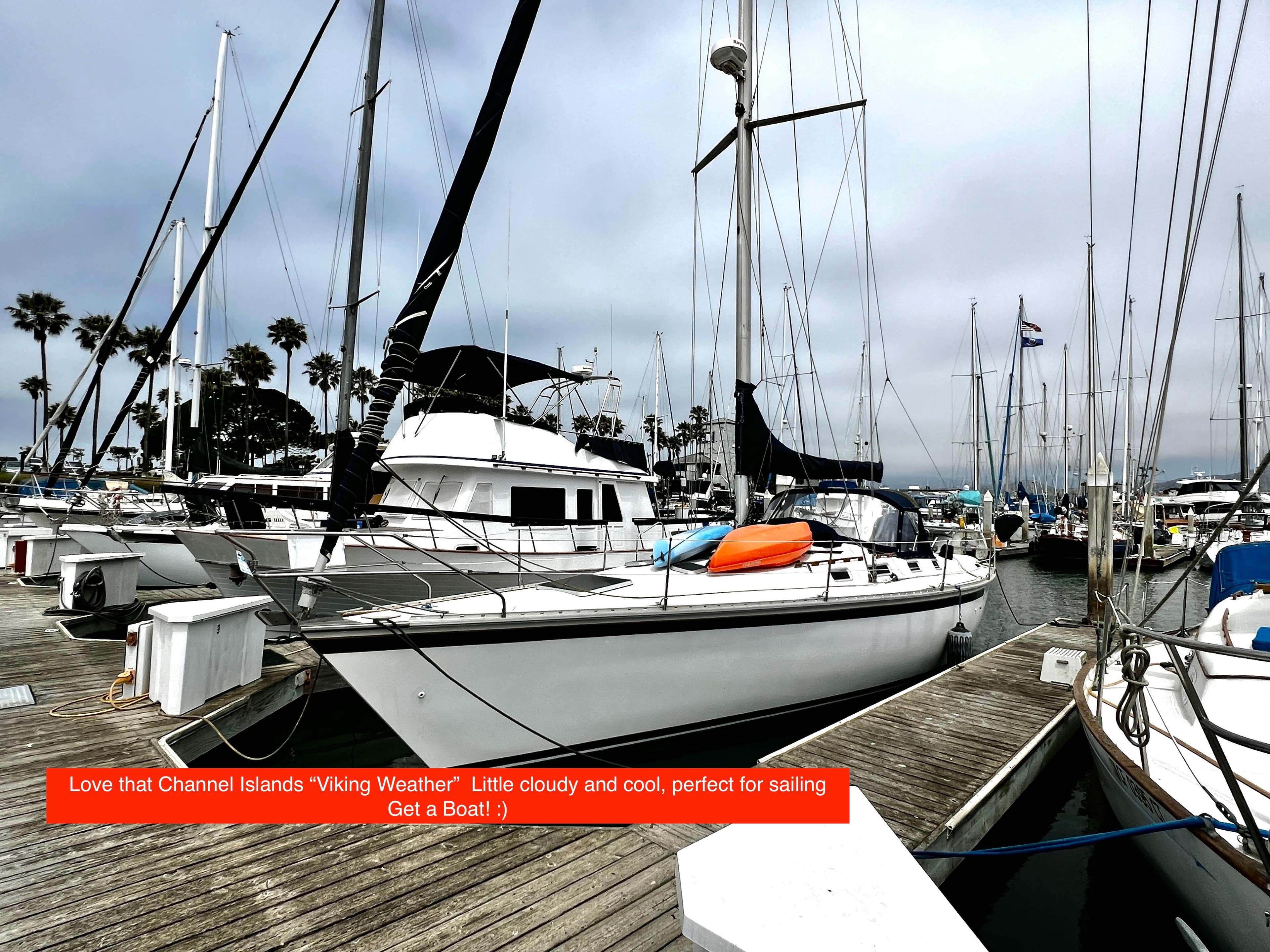 Sailboats docked at a marina under cloudy skies, featuring a 1988 Hunter 40.