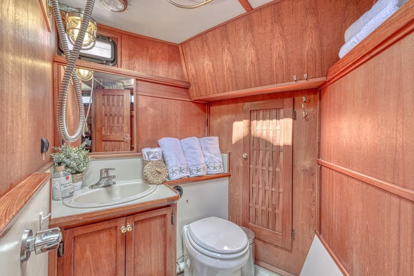Wood-paneled boat bathroom with sink, toilet, and towels; Nielsen 46, 1981 model.