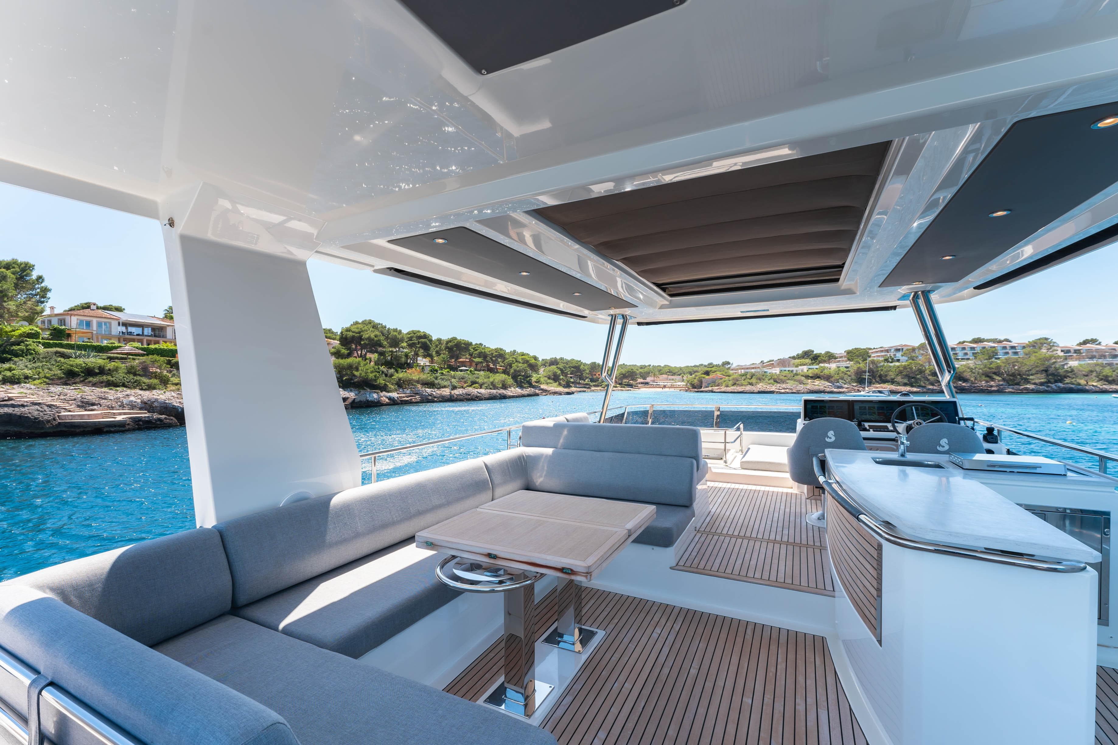 Luxurious deck of 2023 Beneteau Grand Trawler 62 with seating and ocean view.