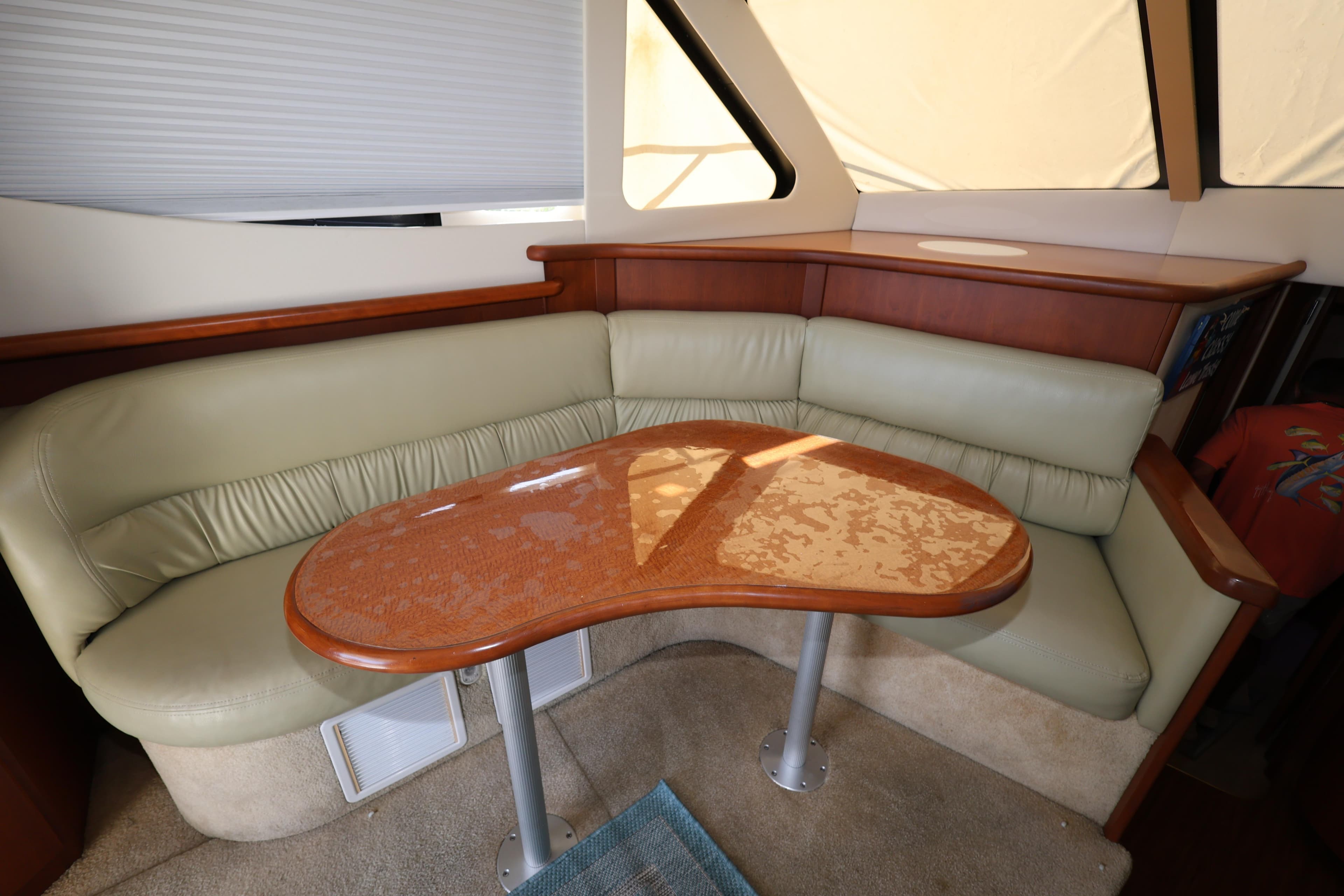 2005 Silverton 34 Convertible yacht interior with beige leather seating and wooden table.