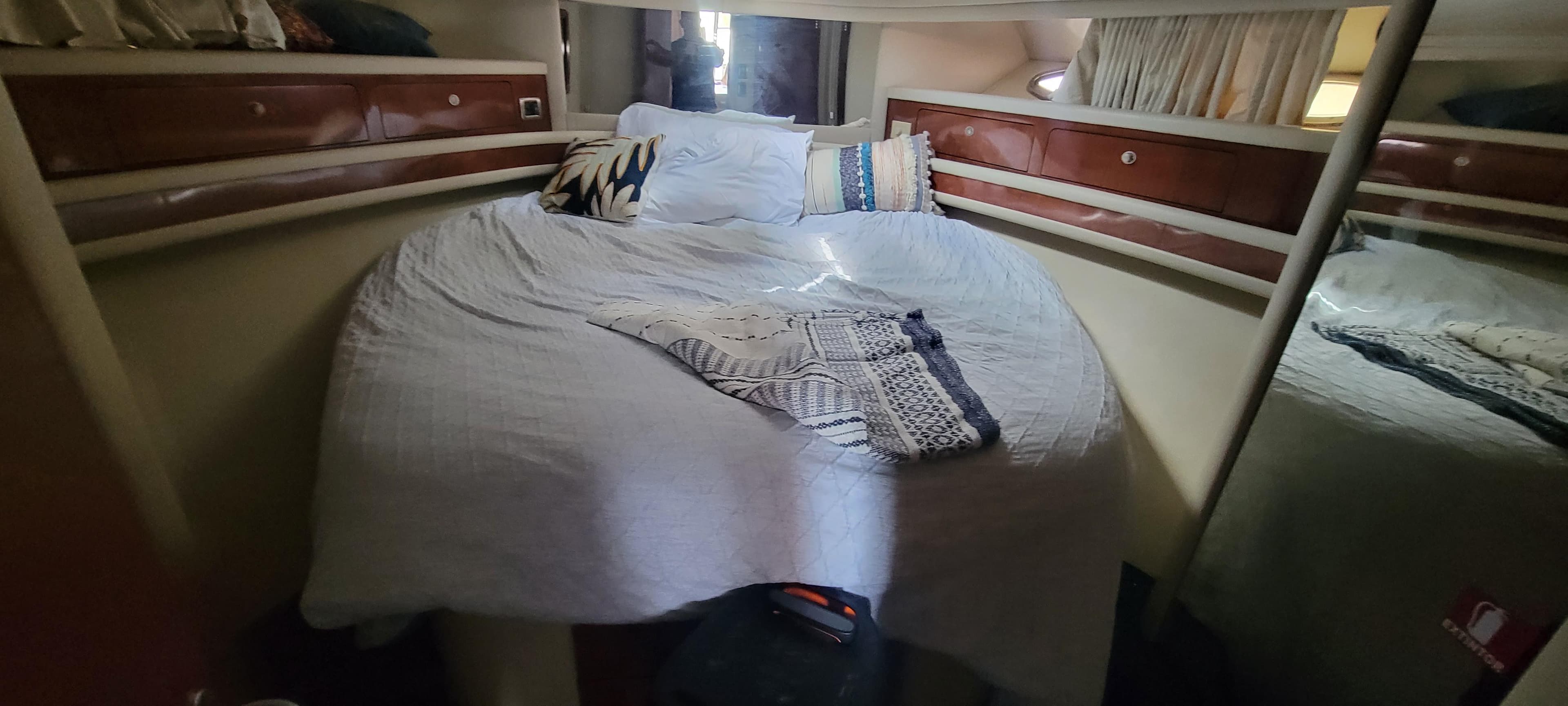 Cozy bedroom in 2004 Sea Ray 480 Sedan Bridge yacht with plush bedding.
