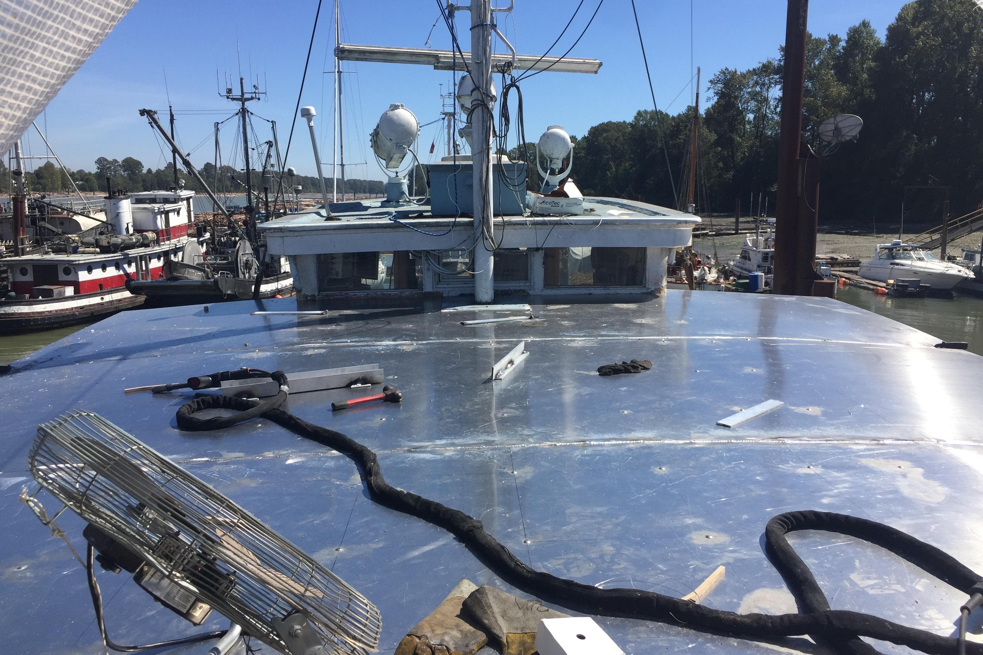 1941 McKenzie Barge & Derrick Co. Ltd Tugboat deck with tools and equipment in a marina setting.