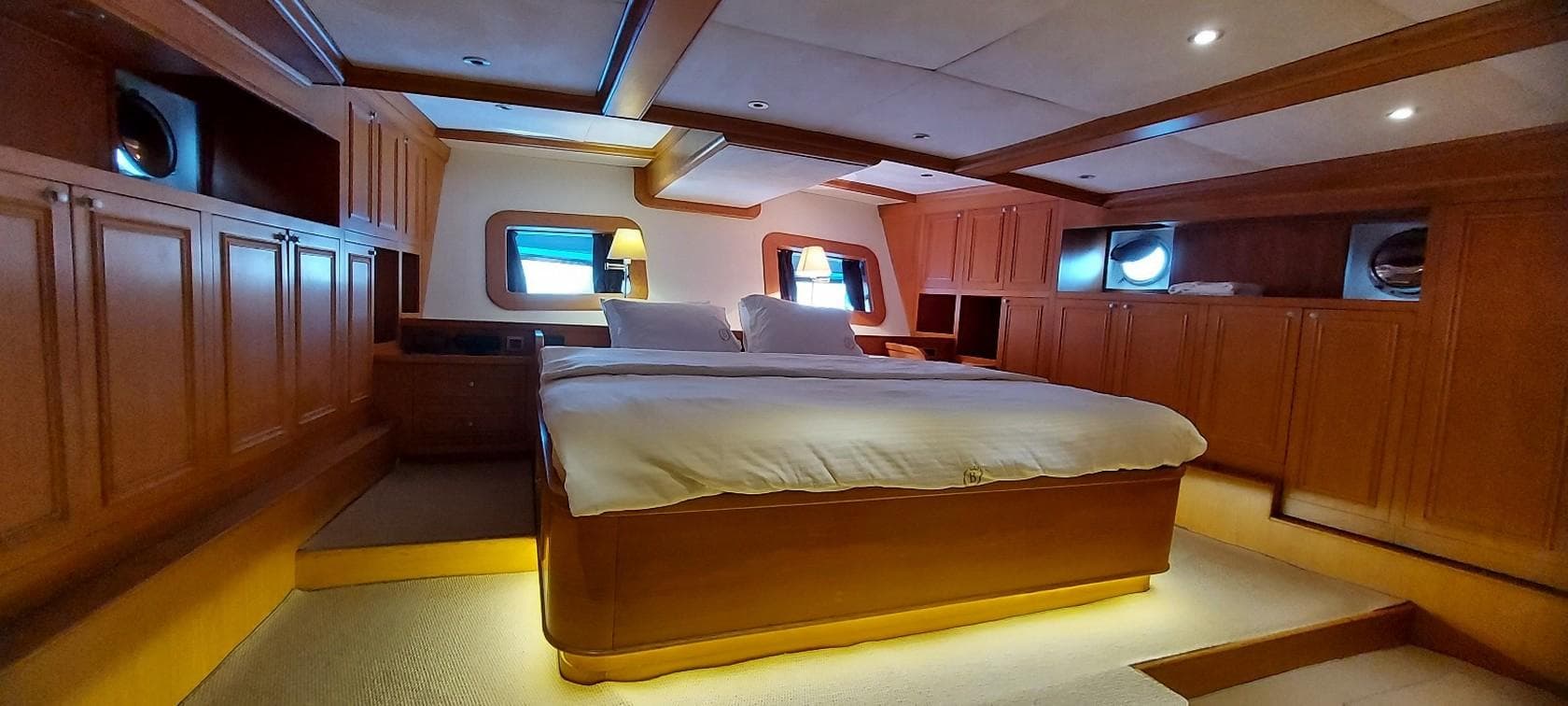 Luxurious cabin interior of 2012 Ketch 37m yacht with wooden furnishings and cozy bed.
