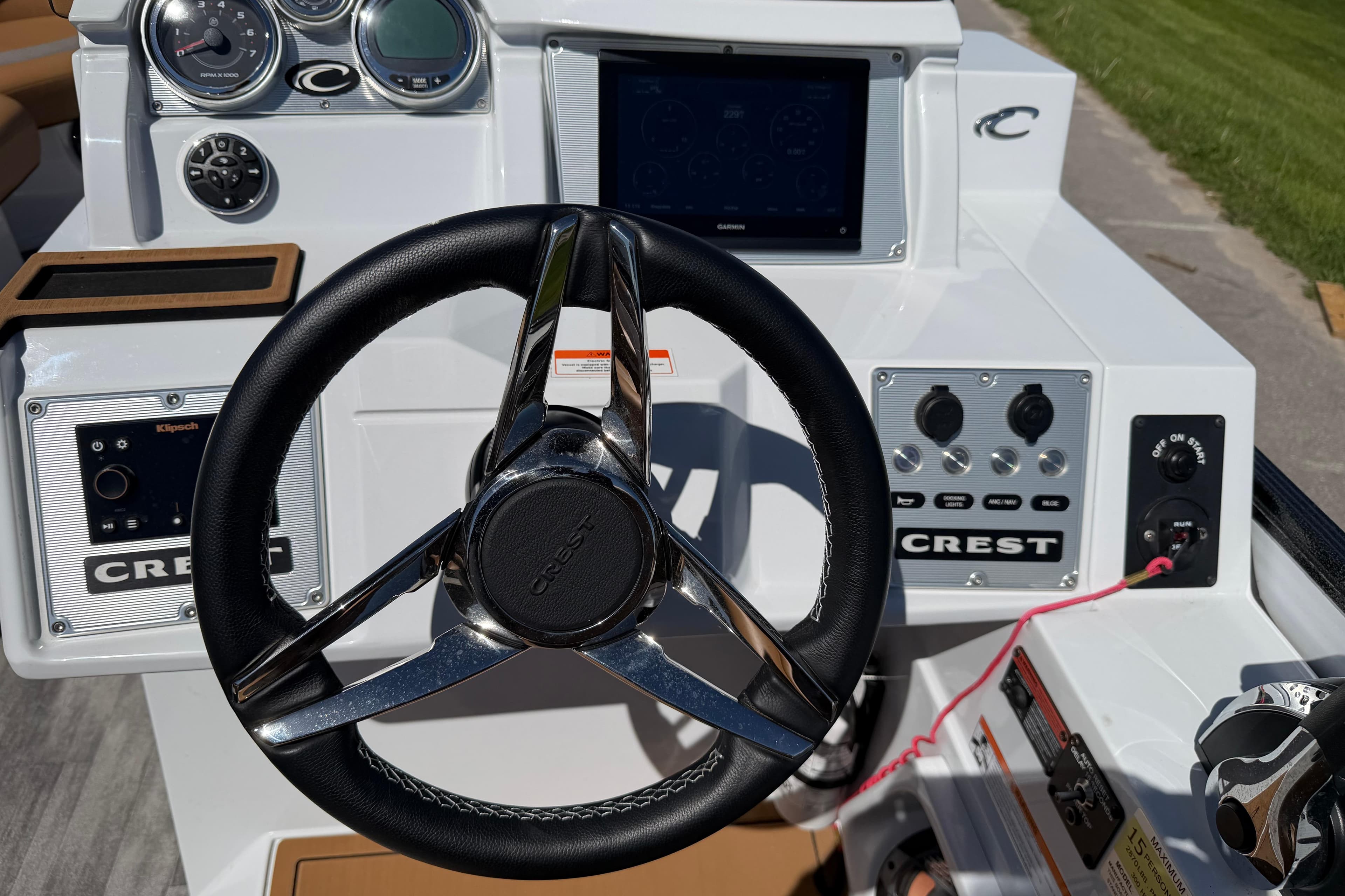 Steering wheel and dashboard of 2022 Crest Savannah 250 SLC boat, featuring modern controls.