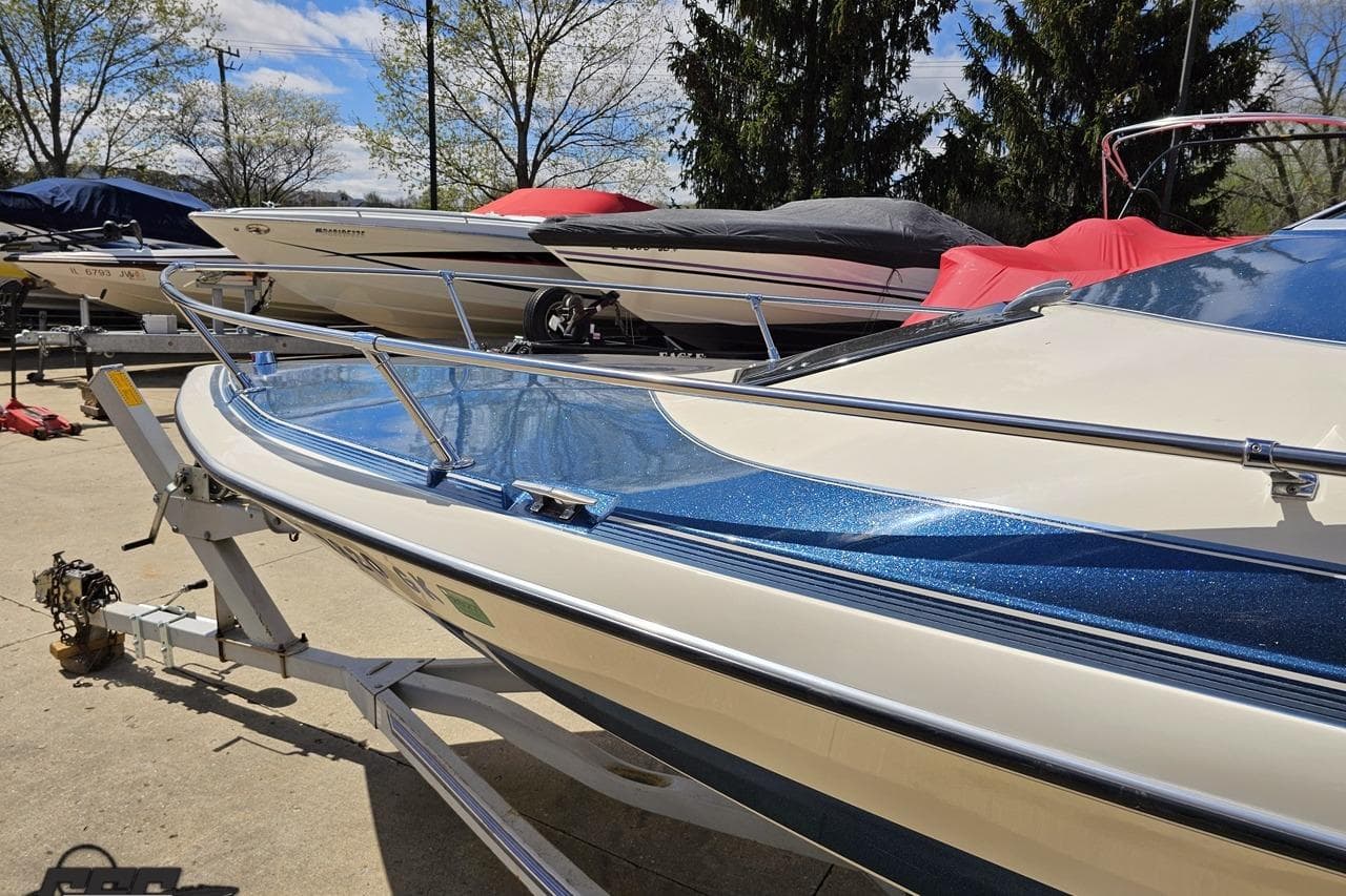1988 Glastron/Carlson CVX-23 boat on trailer, surrounded by covered boats.