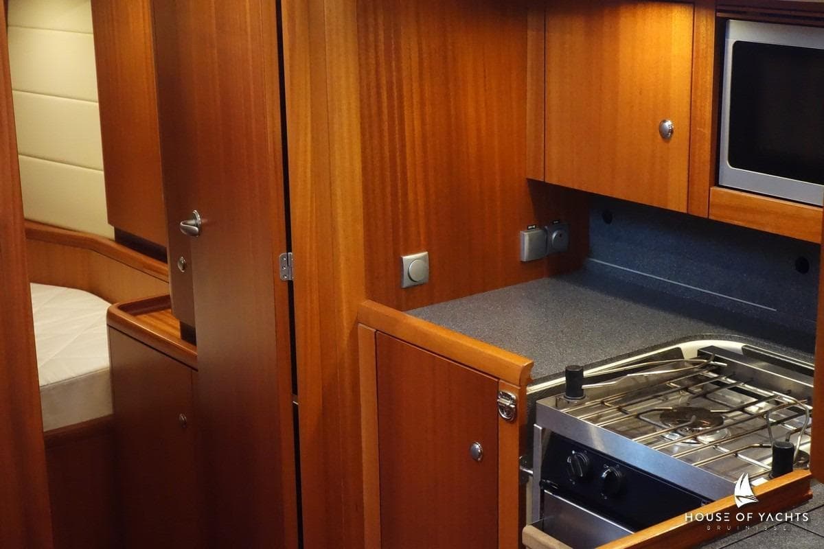 Interior of 2007 Najad 440 AC yacht with wooden cabinetry and compact kitchen area.