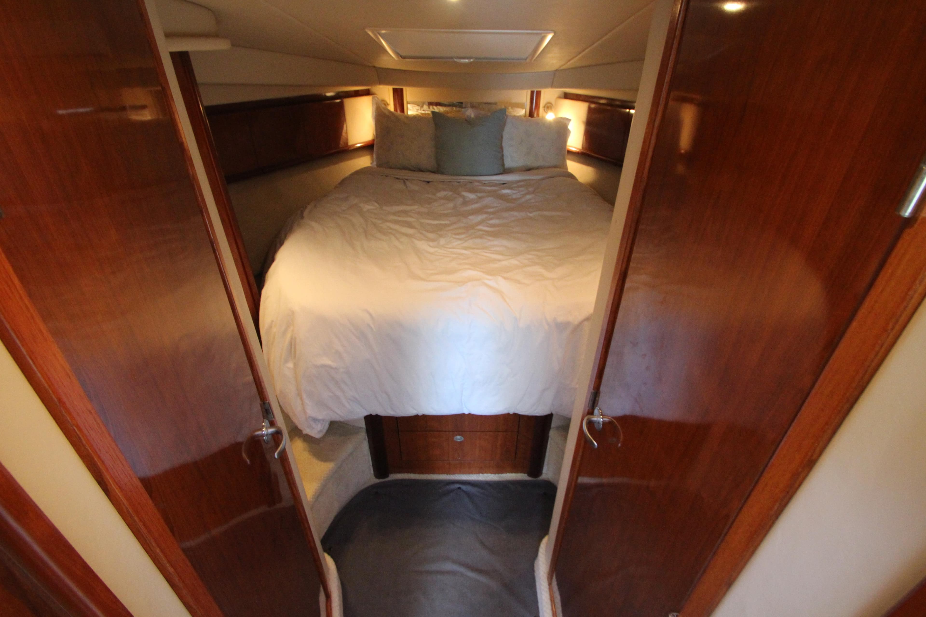 Cozy bedroom interior of 2004 Sea Ray 40 Sundancer yacht with wooden accents.