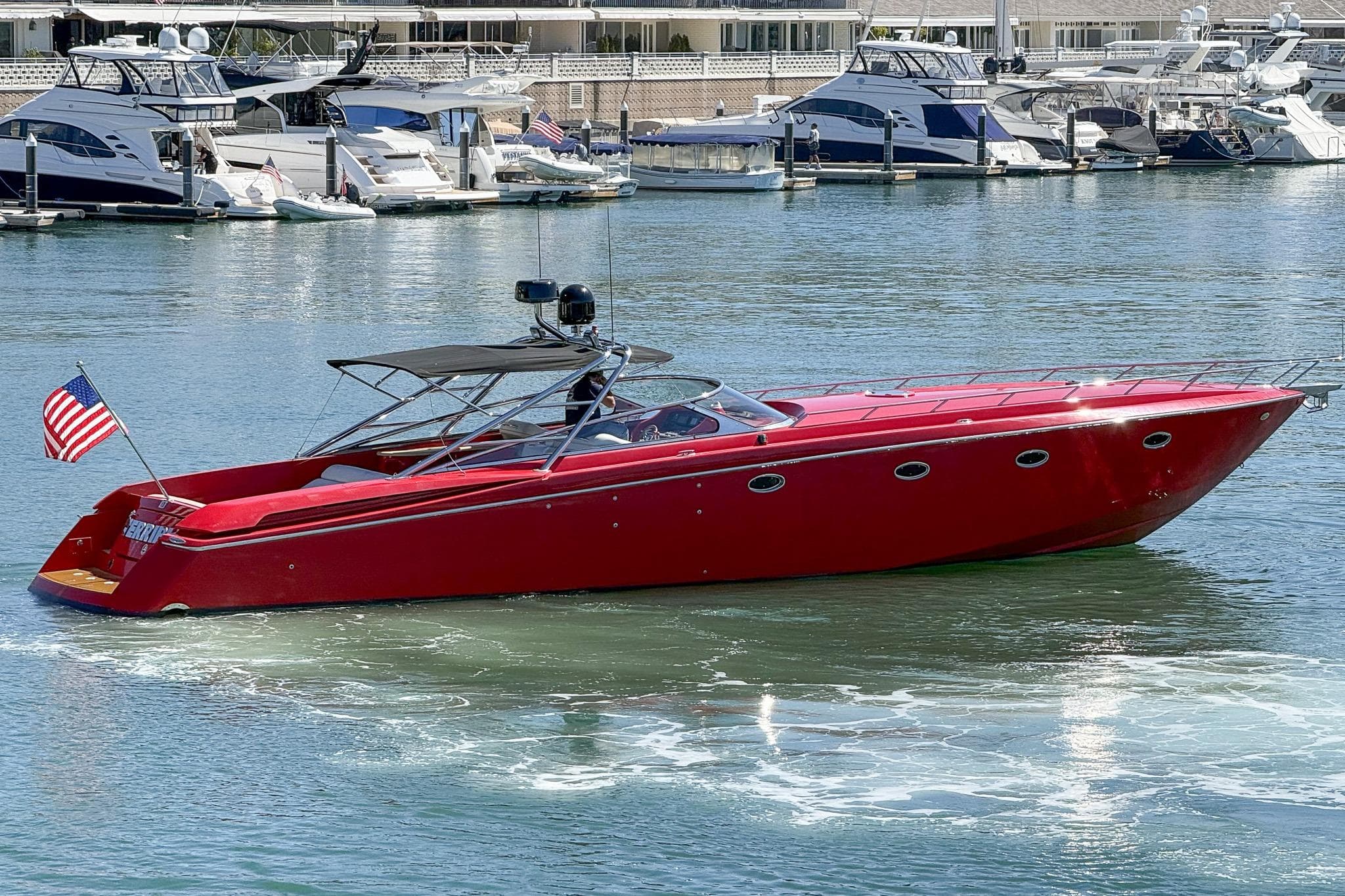 Red 2002 Hallett Custom High Performance Express Cruiser on water, with marina background.