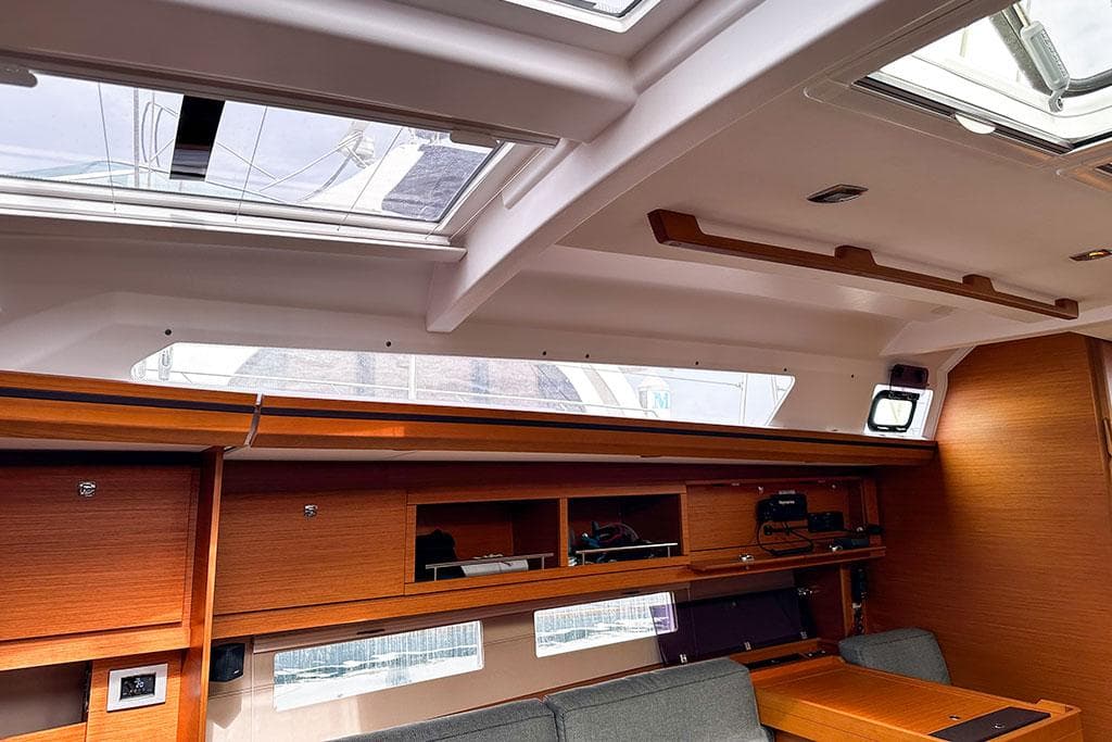 Interior of 2021 Dufour 56 yacht with skylights and wooden cabinetry.