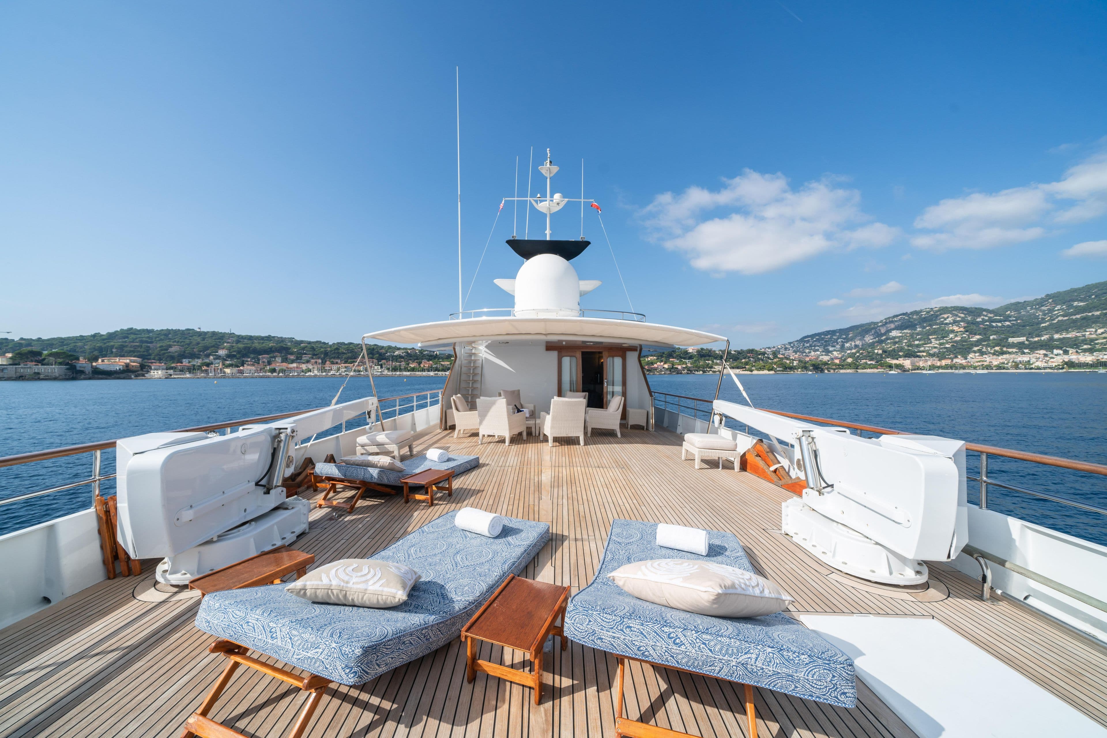 Luxurious 1978 Feadship Classic yacht deck with sun loungers and scenic ocean view.