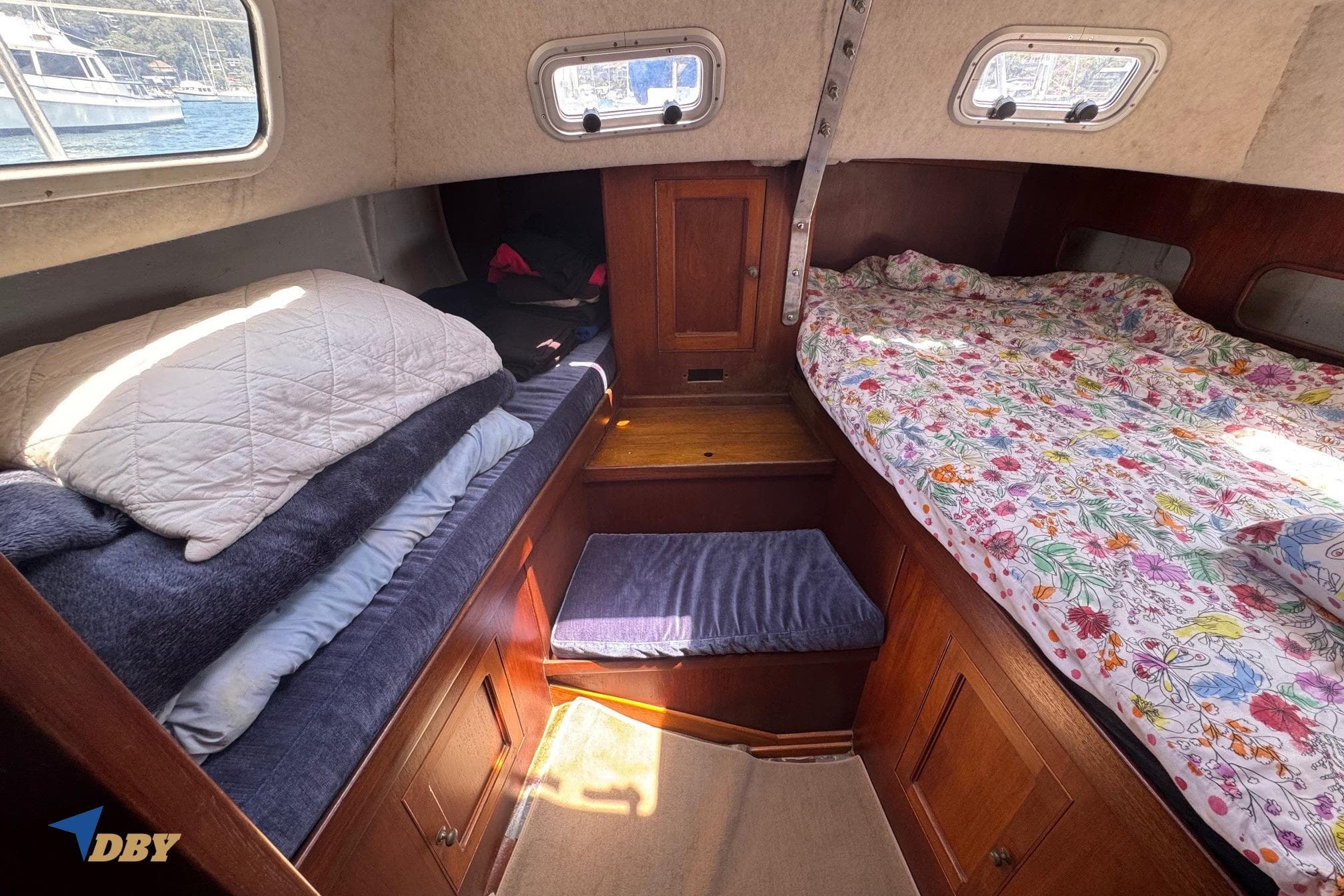 Cozy cabin interior of 1987 Bowman 47 sailboat with beds and wooden storage.