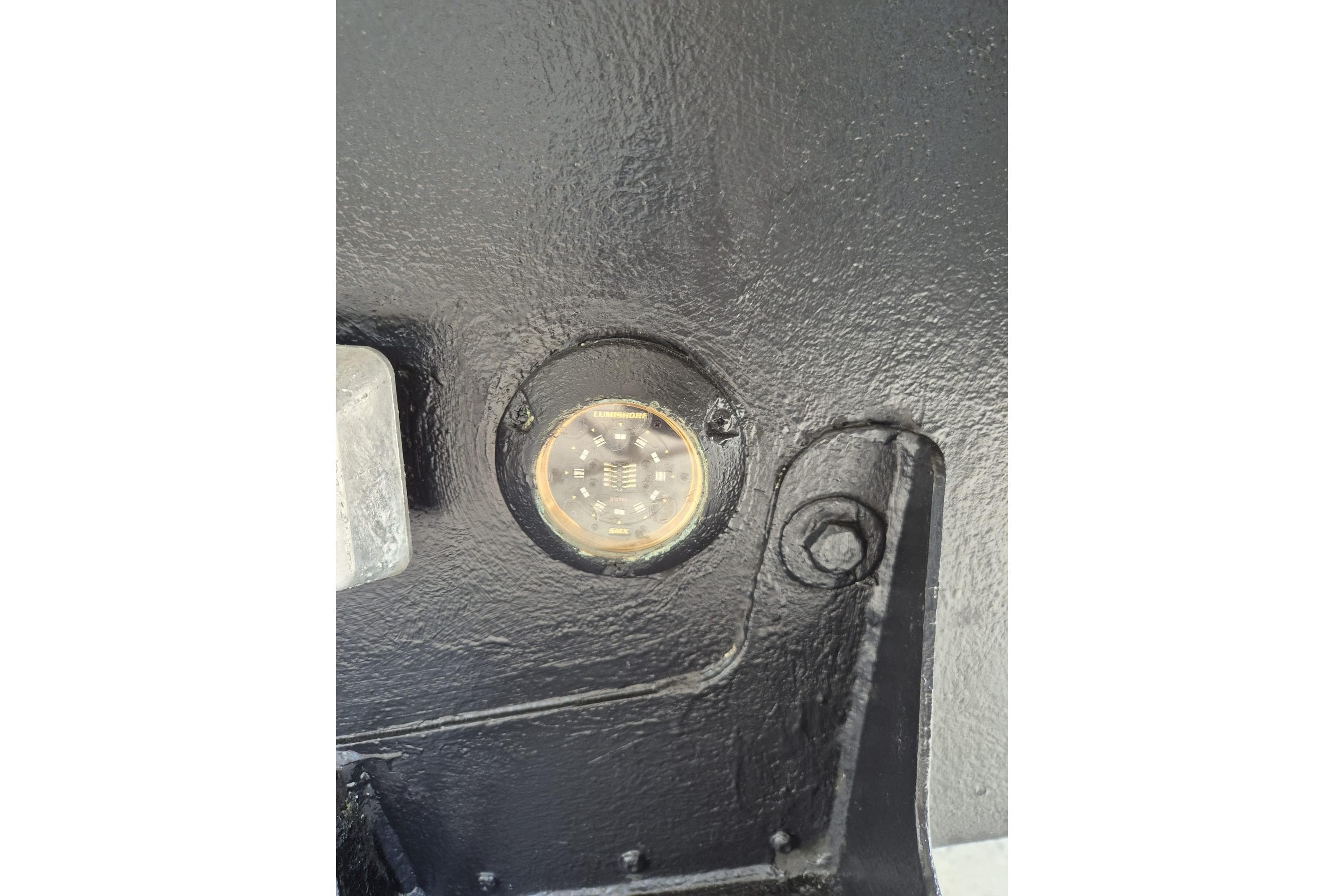 Close-up of Monte Carlo 52 yacht's hull detail, showcasing a circular component, 2022 model.