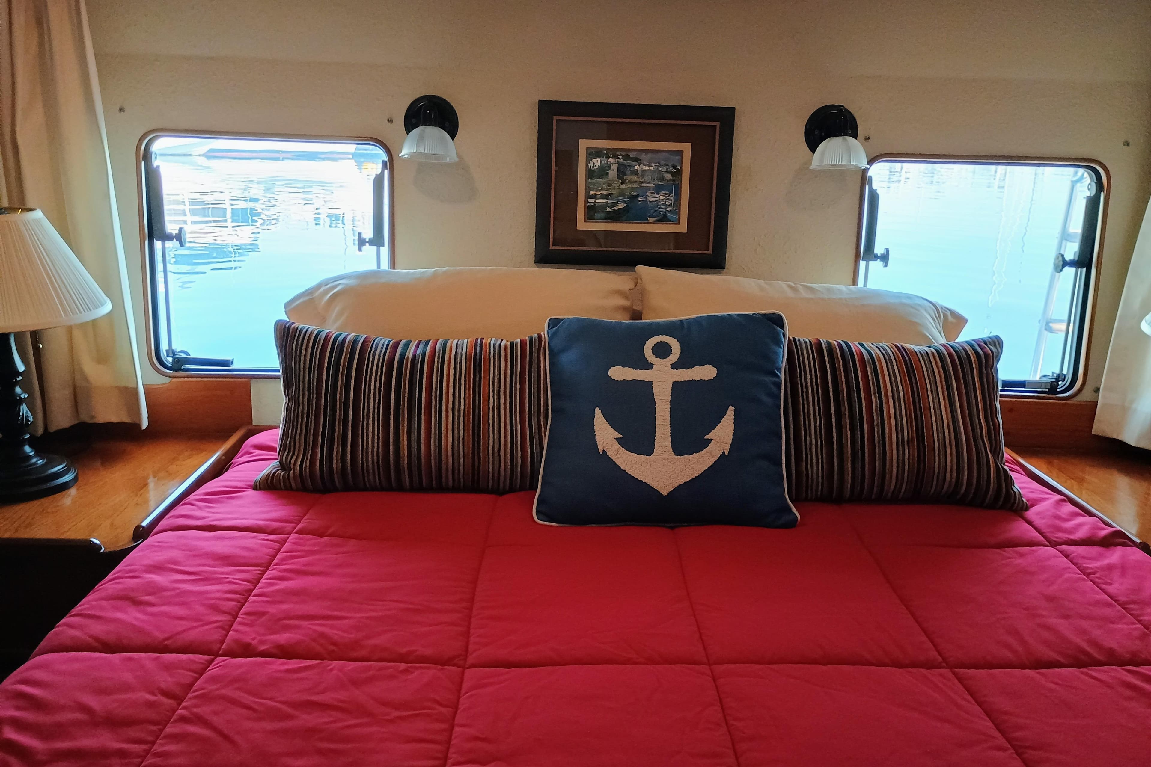 Cozy bedroom in 1988 Vantare 46' Aft Cabin yacht with nautical-themed decor.