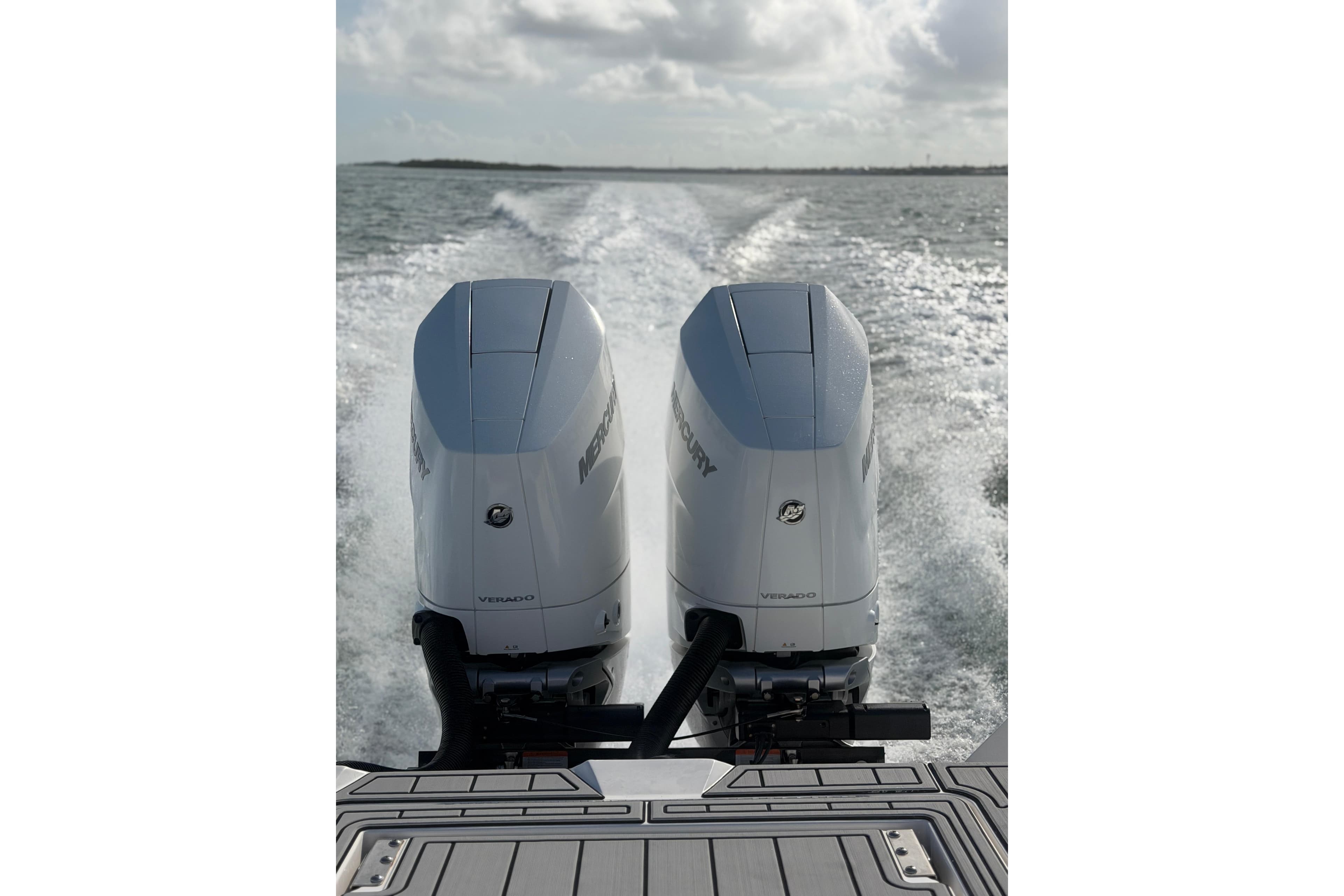 Twin Mercury outboard engines powering a 2024 Tidewater 3100 Carolina Bay boat on open water.