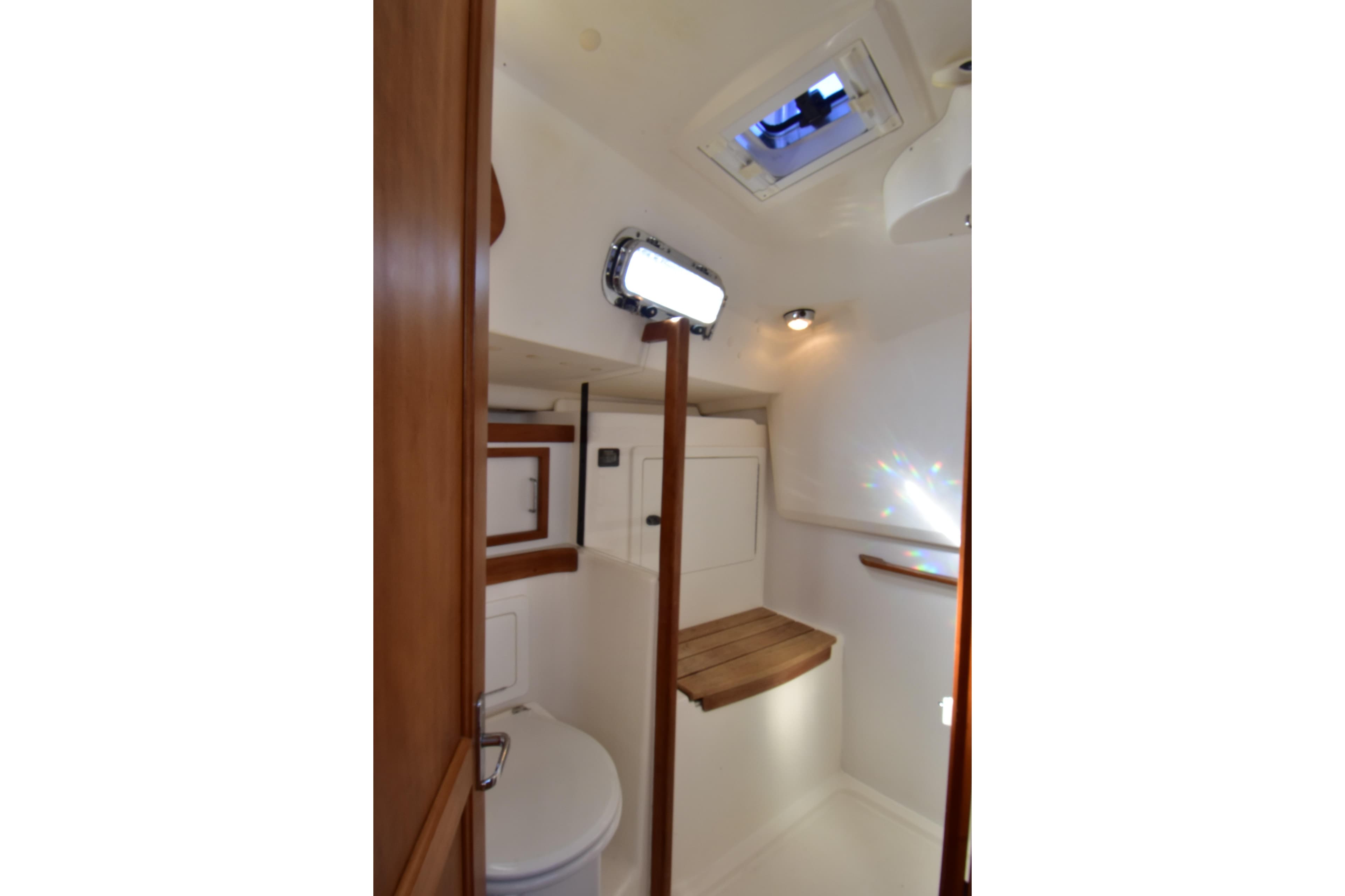 2004 Sabre 386 yacht bathroom interior with wooden accents and overhead hatch.
