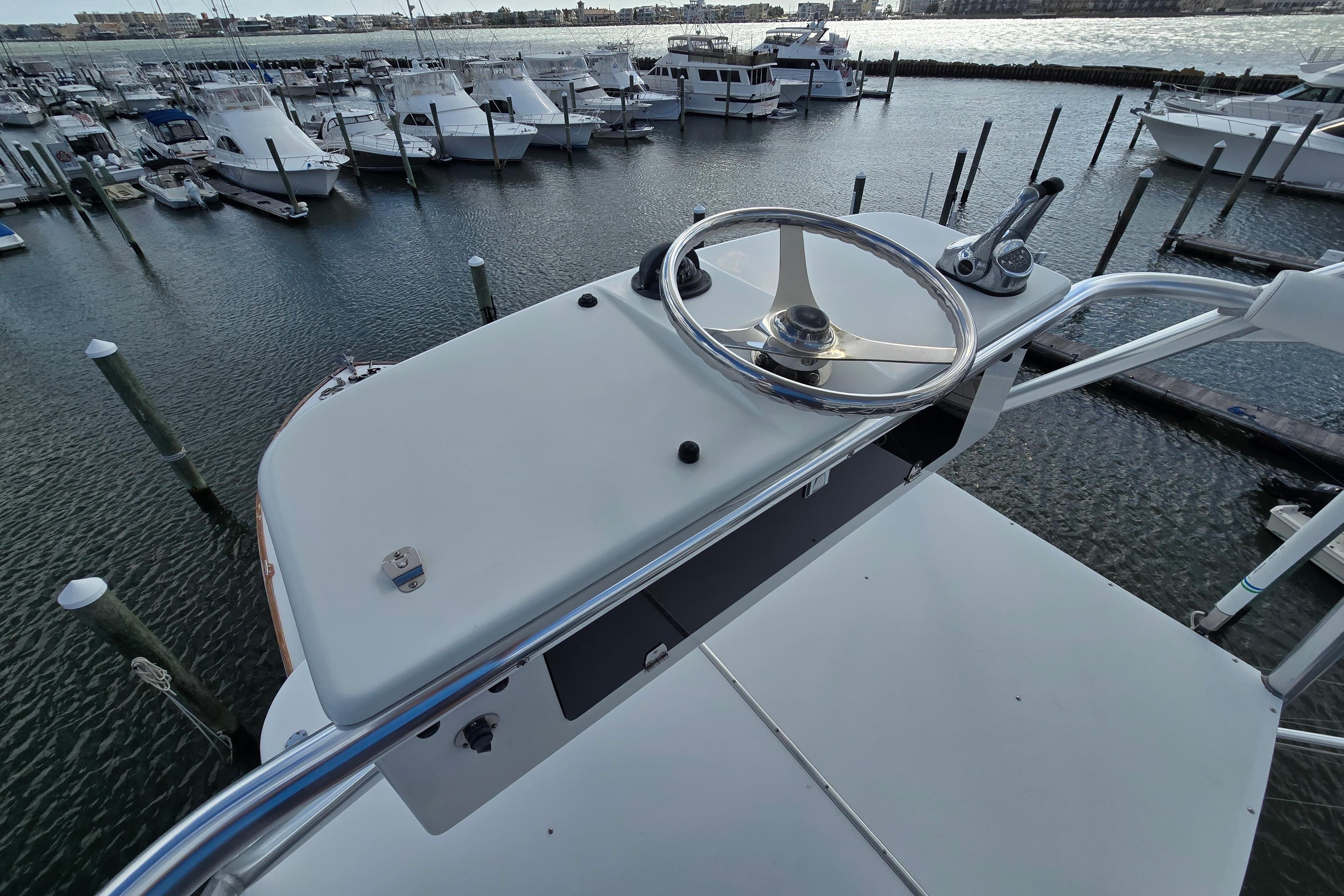 Helm of Ocean Yachts 55 Super Sport 1982, overlooking marina with docked boats.
