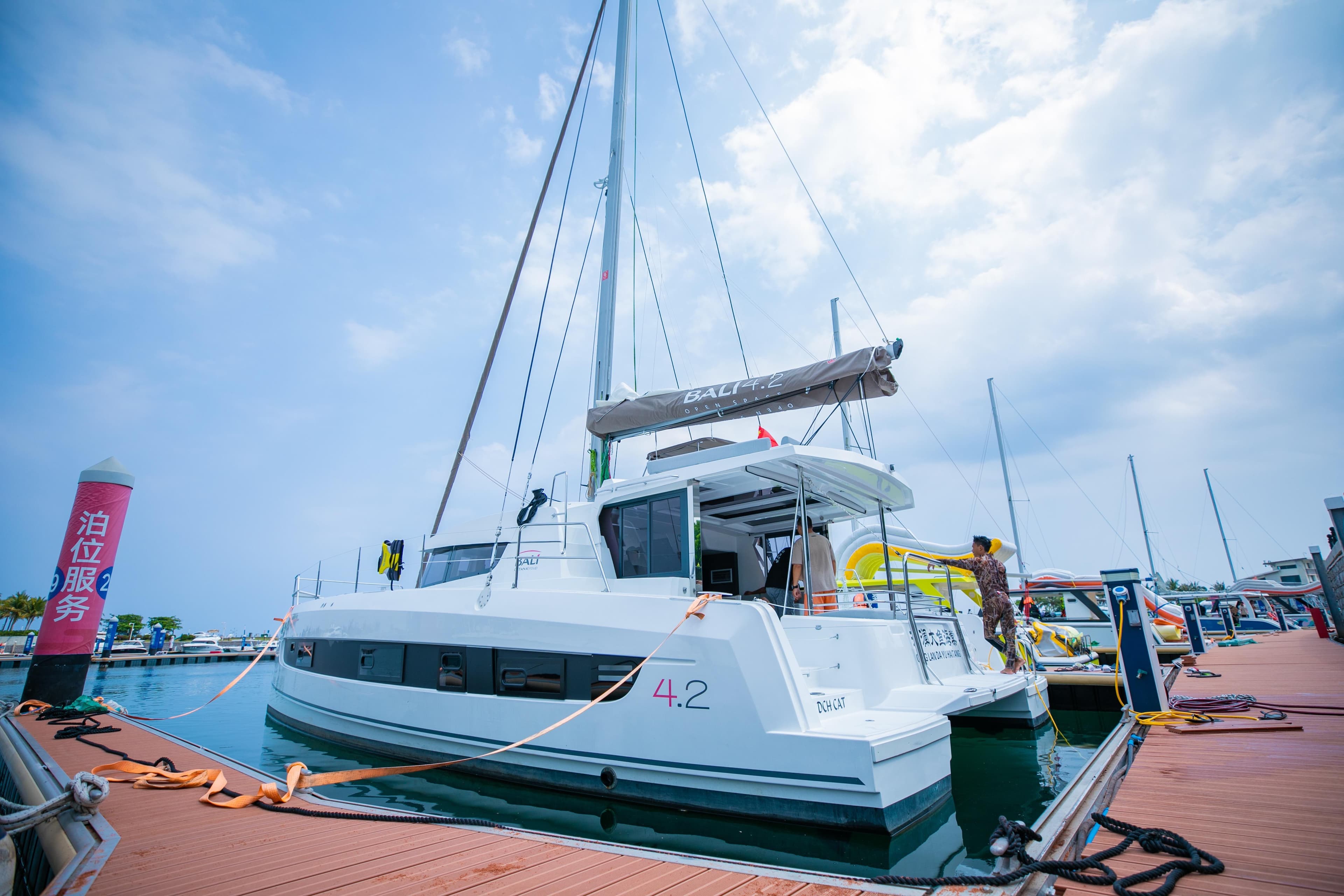 Sailing catamaran Bali 4.2, 2021 model, docked at marina under blue sky.