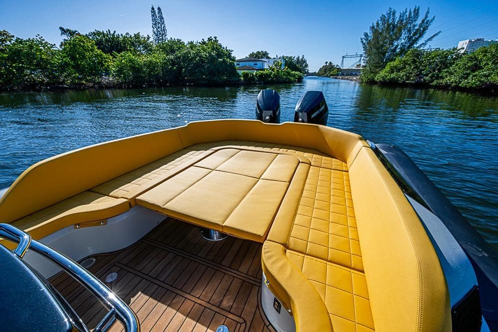 2025 SACS Strider 11 boat with luxurious yellow seating on a serene waterway.