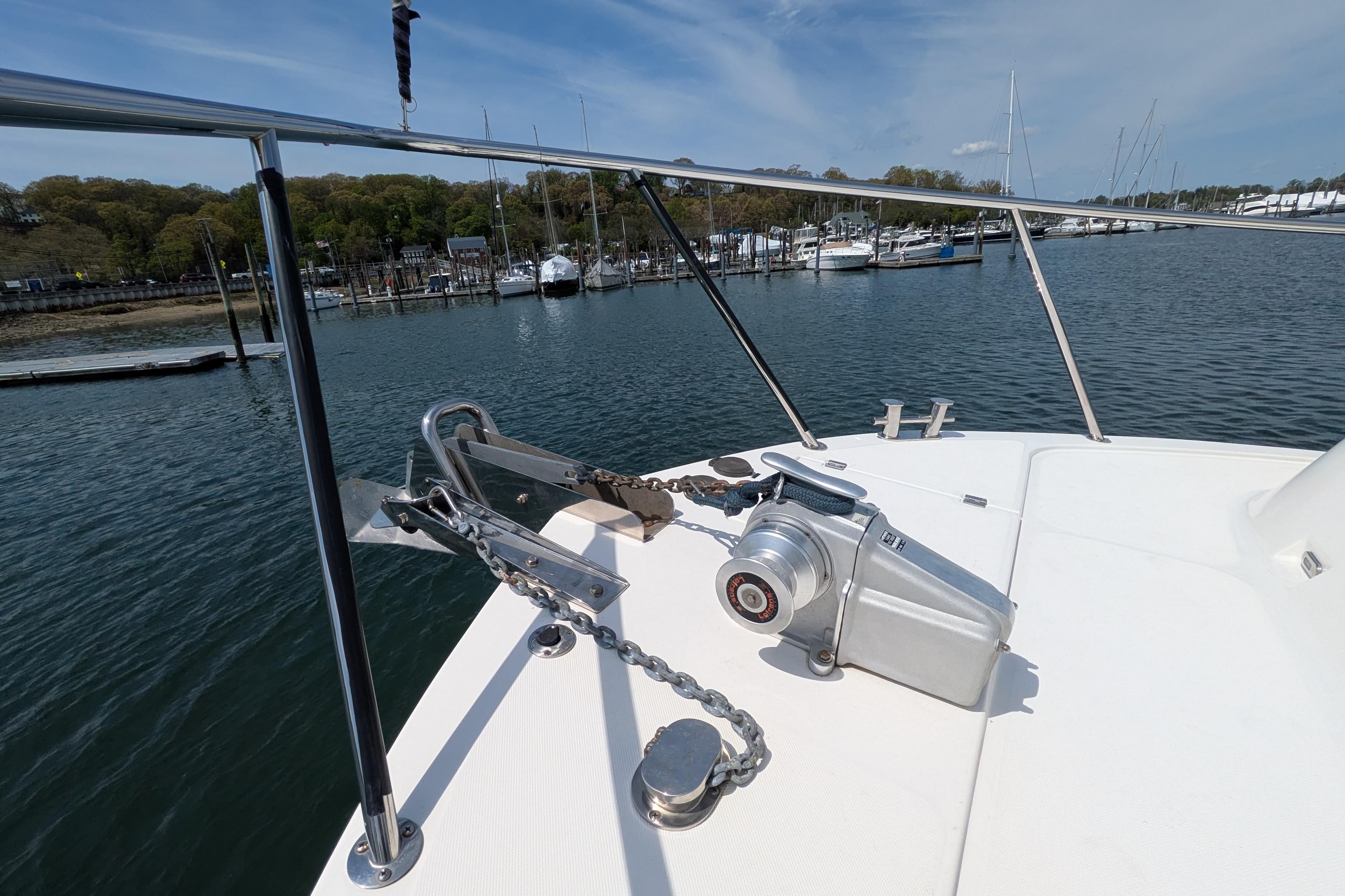 Bow of 2005 American Tug 41 with anchor and winch, docked in a marina.