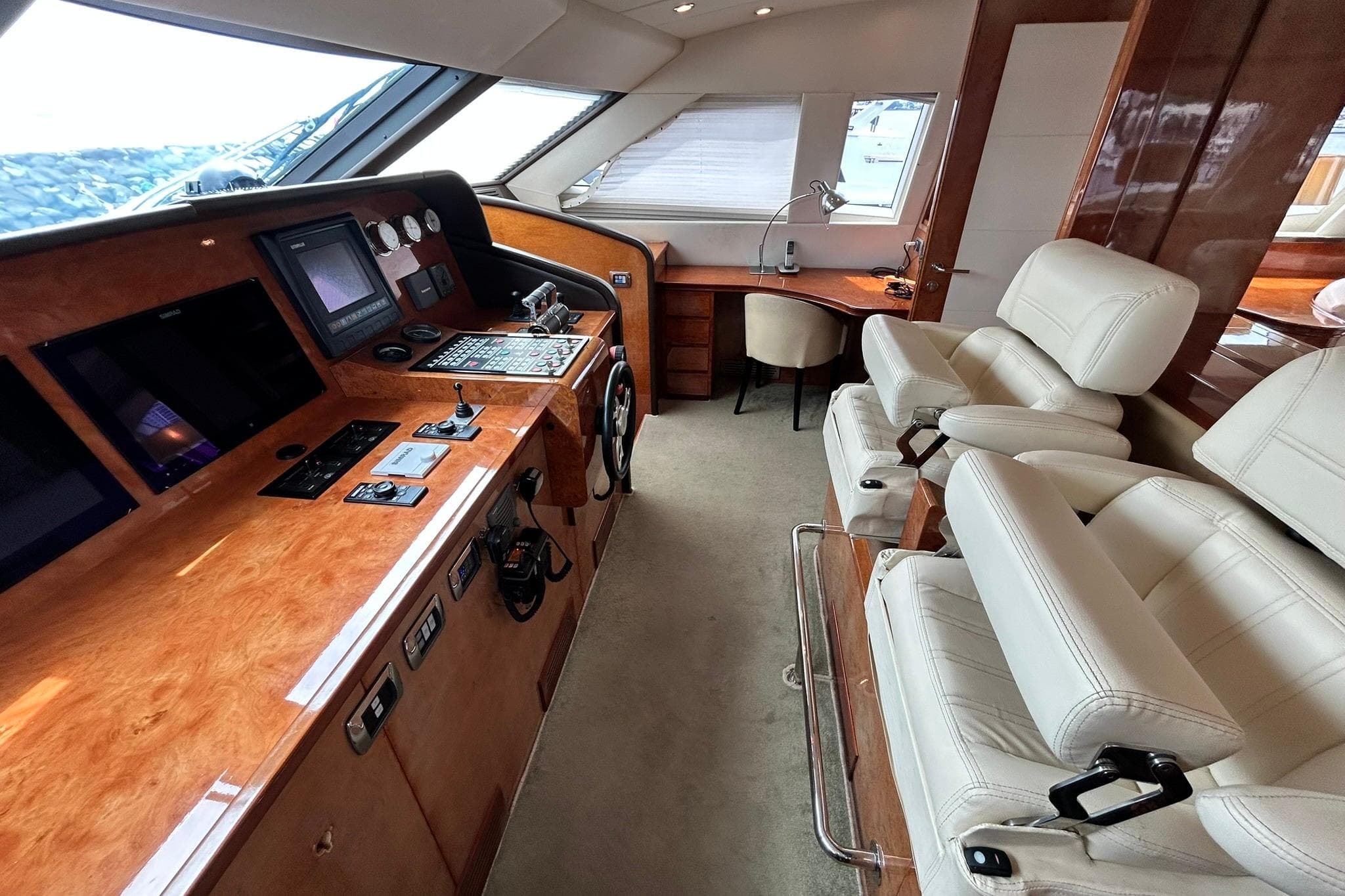 Luxurious helm of 2010 Versilcraft Euroyacht Planet 125S Hardtop with leather seating and control panels.