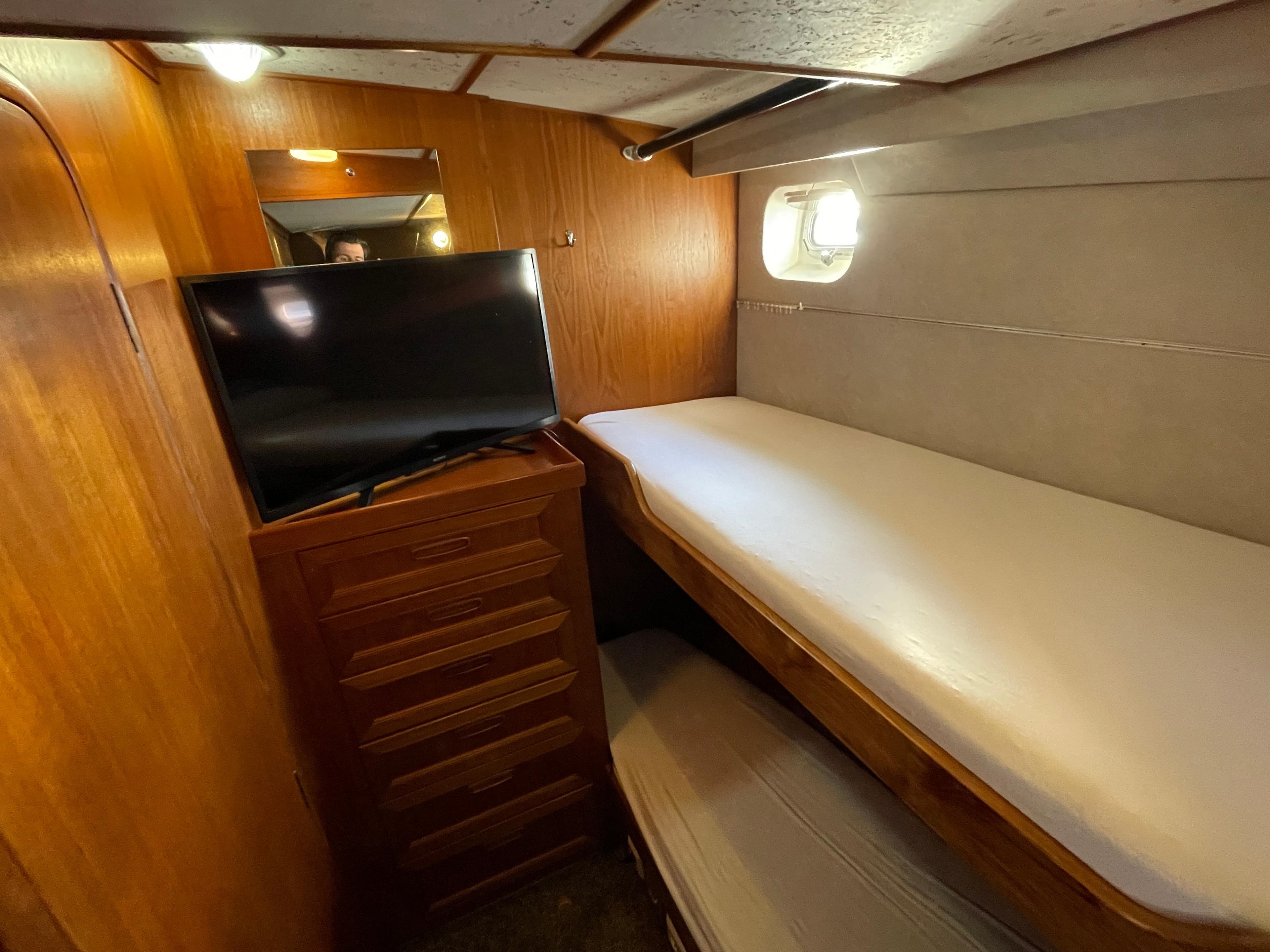 Cozy cabin interior of 1986 Moody Trawler 50 with bunk beds and TV.