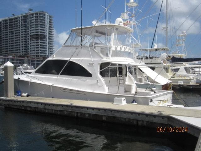 2004 Ocean Yachts Super Sport docked at marina with high-rise buildings in background.