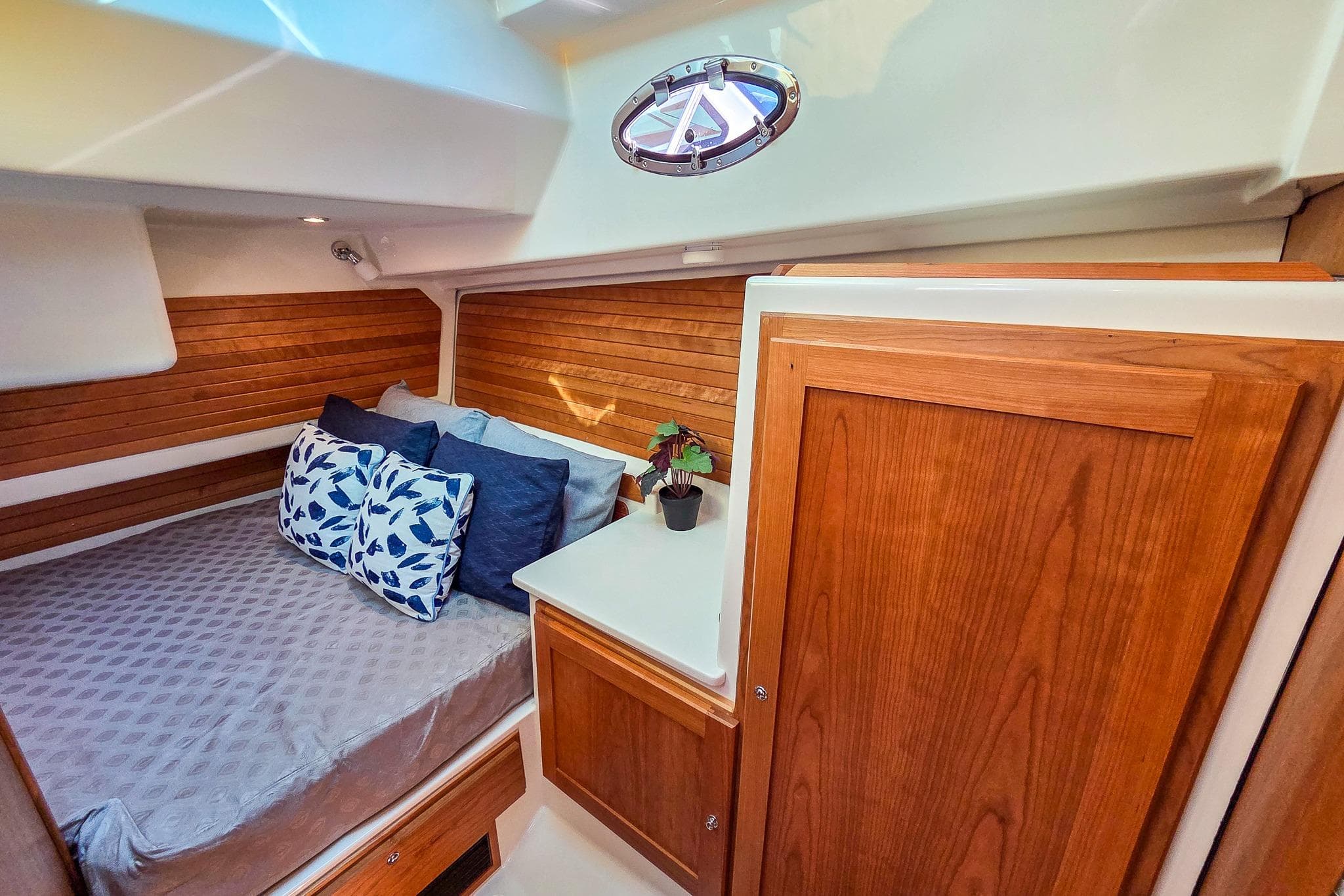 2026 Back Cove 412 cabin interior with cozy bed, wooden accents, and decorative pillows.