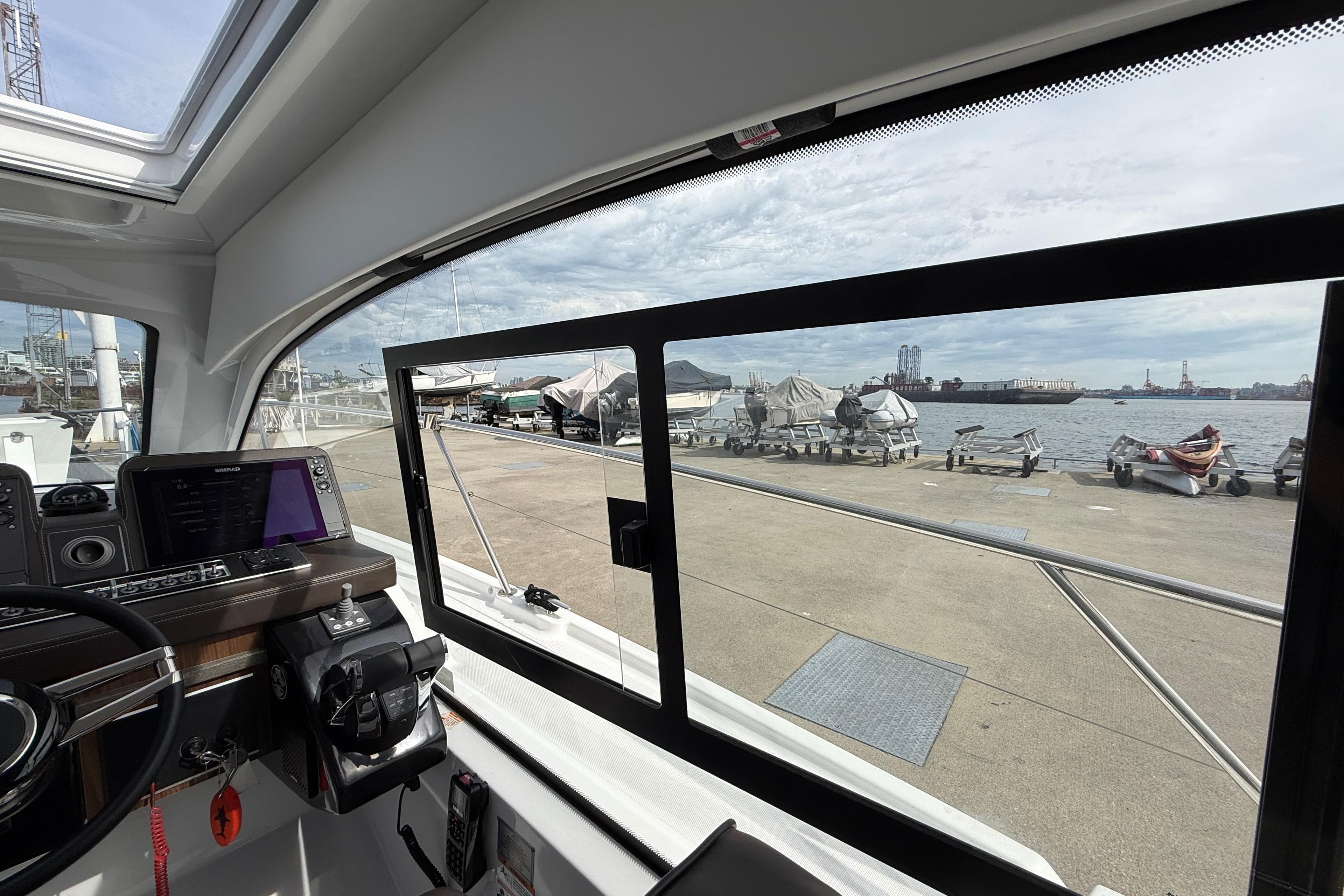 Interior view of 2022 Four Winns V355 Coupe OB boat at a marina.