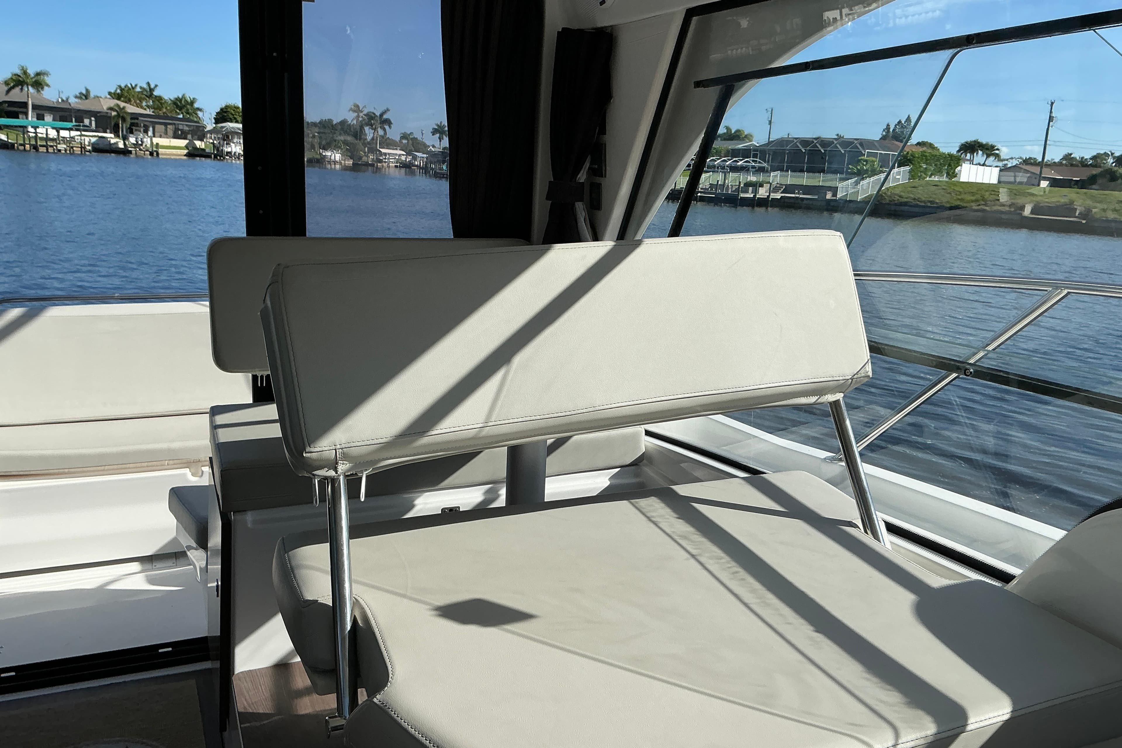 Interior view of 2022 Beneteau Antares 9 boat with seating and waterfront backdrop.