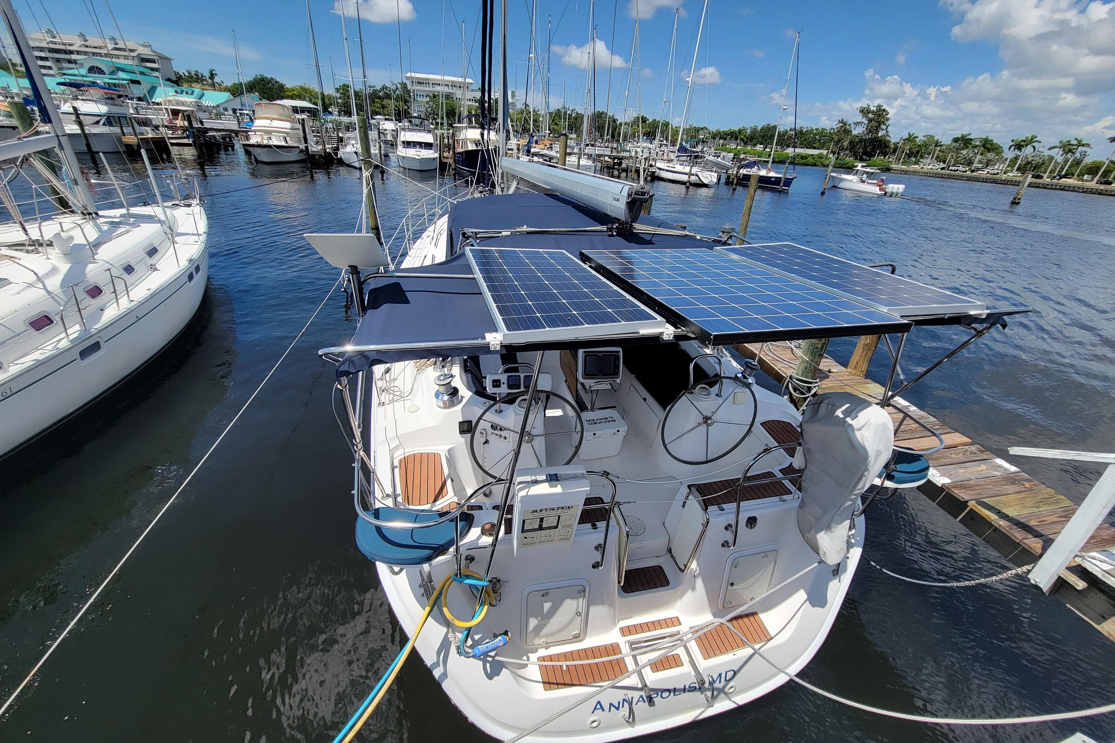 2009 Hunter 49 sailboat with solar panels docked at a marina.