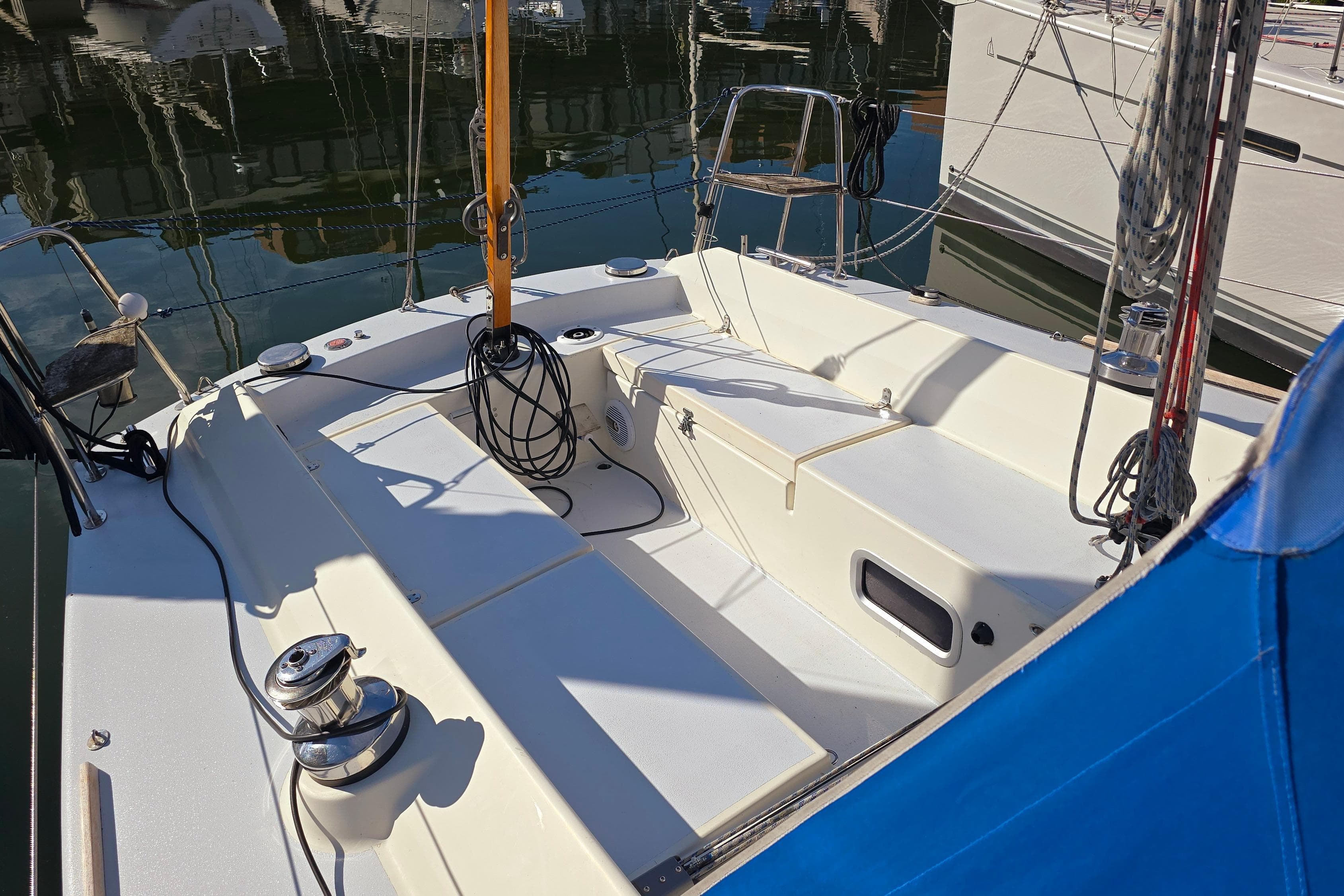 2003 FF Boats 1100 sailboat cockpit with ropes and winches, docked in marina.