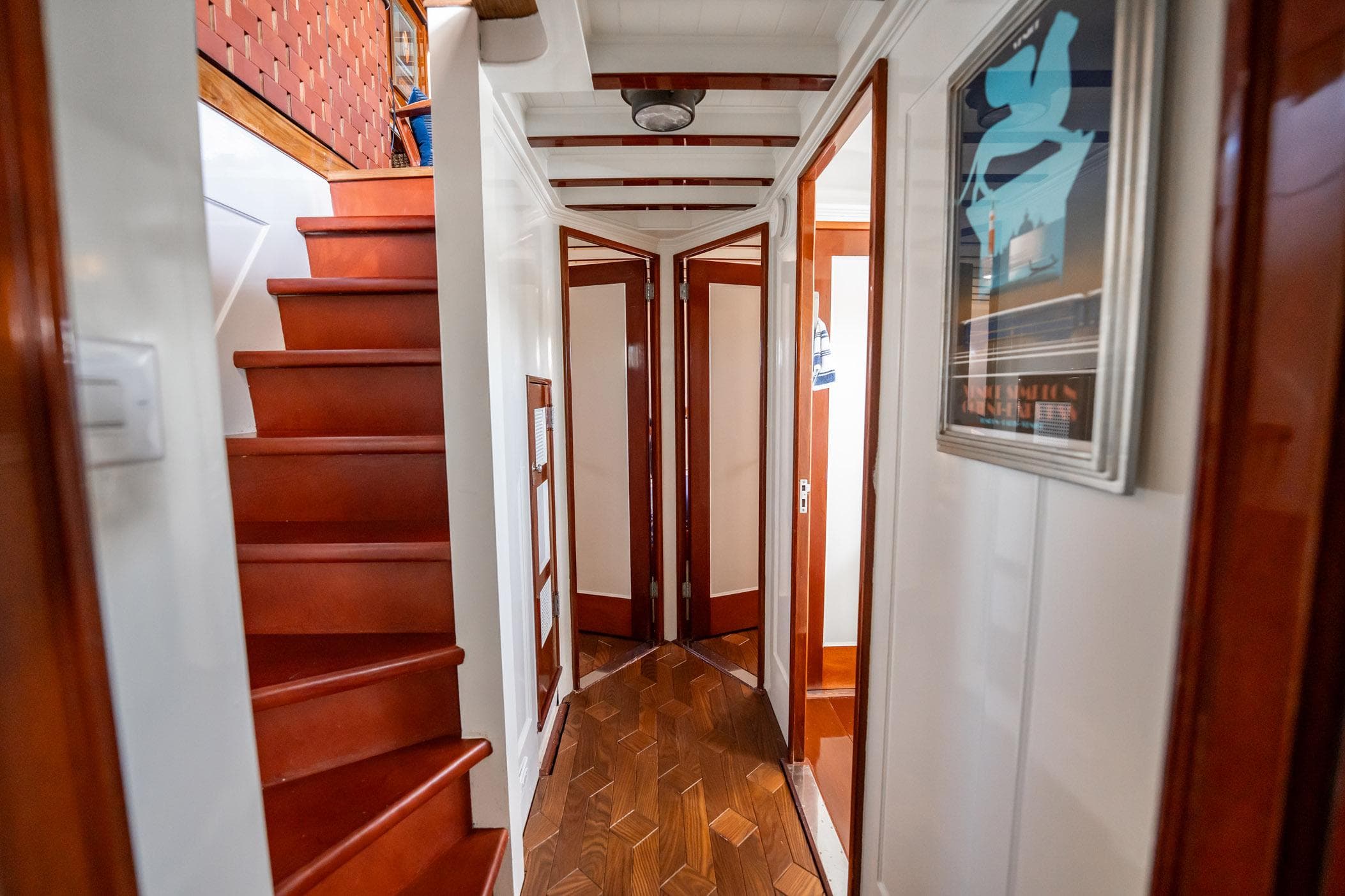 Interior of 1937 Trumpy 58 yacht with wooden stairs and hallway.