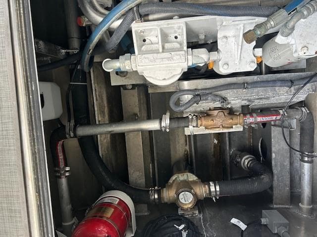 Engine compartment of 2023 Smoky Mountain asymmetrical foil-assisted catamaran, showing mechanical components and fire extinguisher.