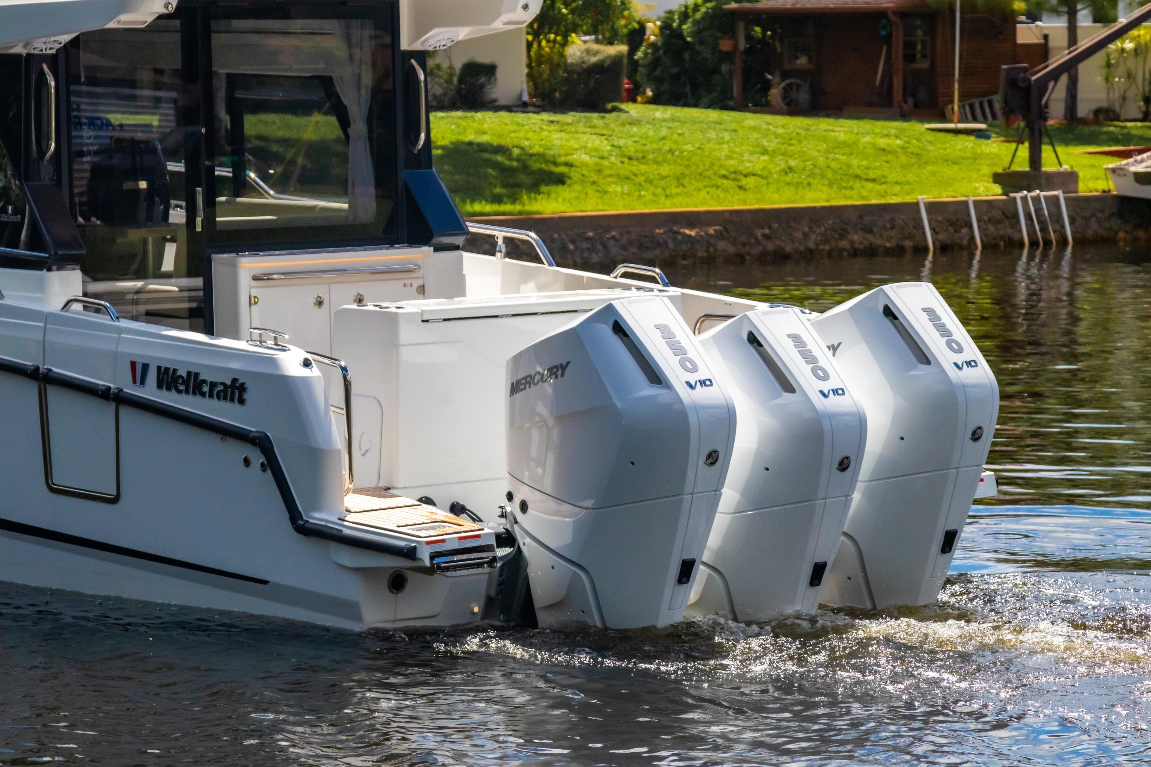 2025 Wellcraft 38 Explorer with triple Mercury V10 engines on a calm waterway.