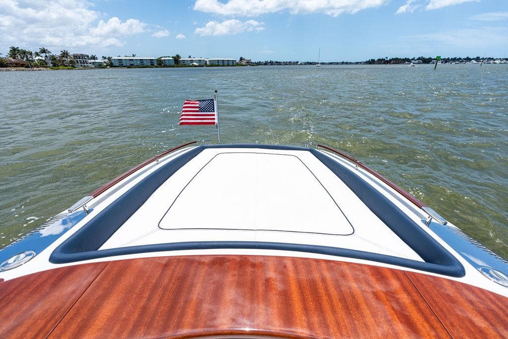 2015 Riva Aquariva Super boat on water, American flag, sunny day.