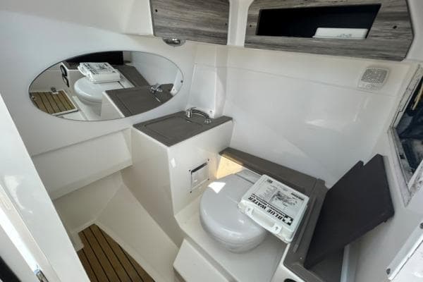 2019 Edgewater 262 CX boat interior with toilet, sink, and mirror.