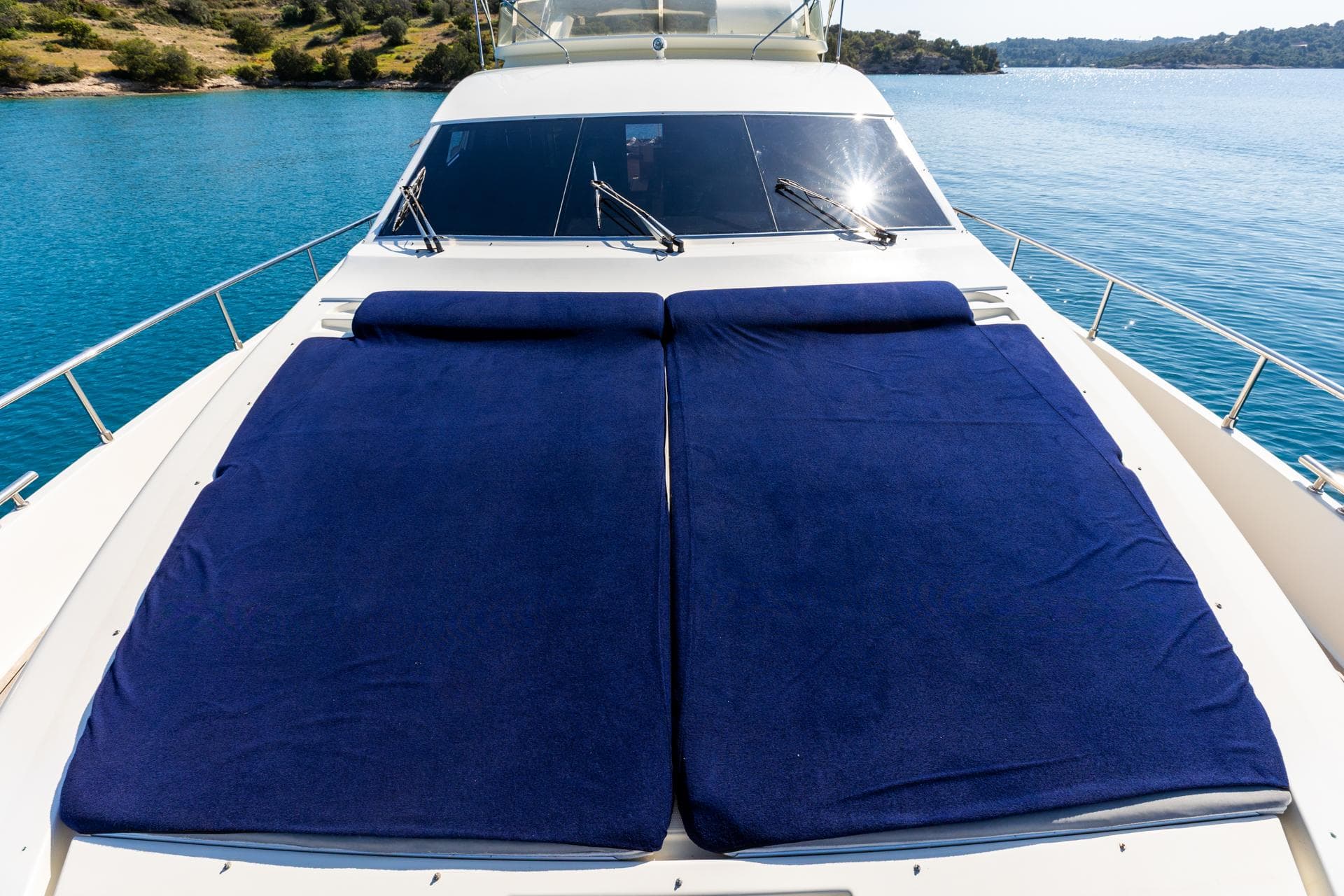 Luxurious 1999 Ferretti Yachts 80 with sunbathing deck on tranquil blue waters.