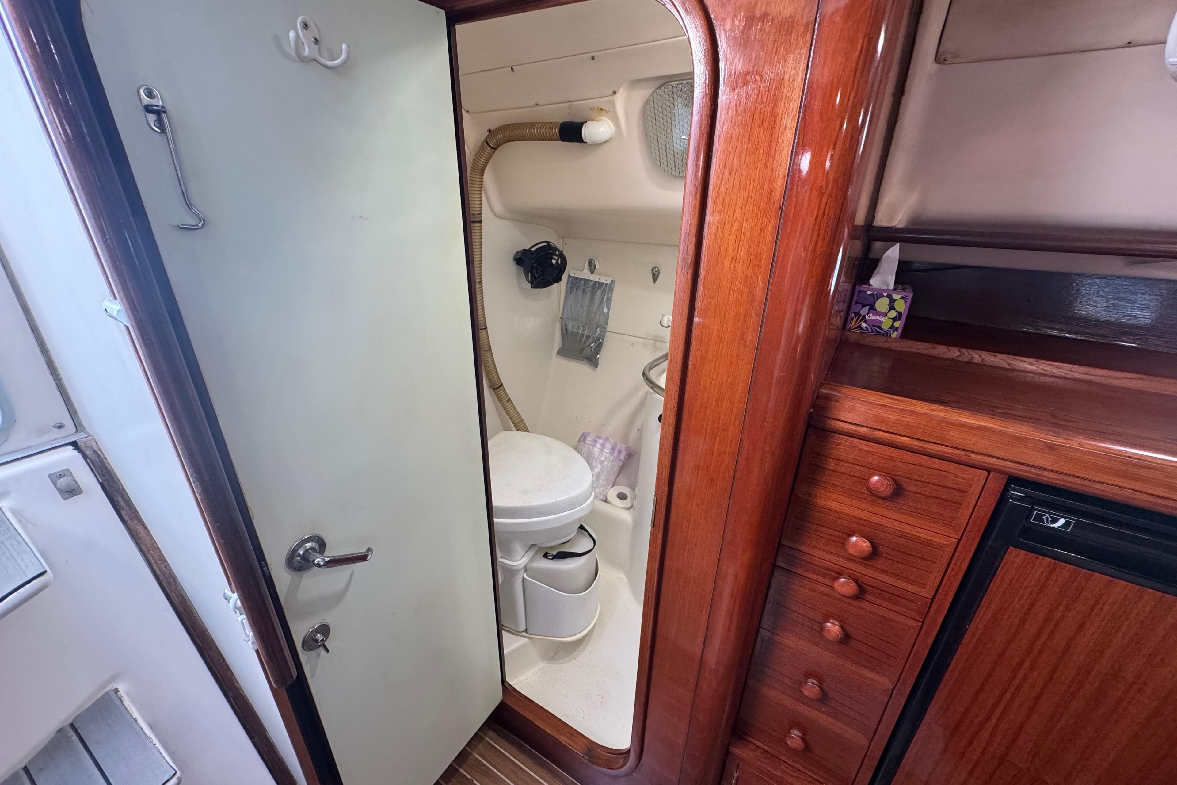 Interior of a 1994 Beneteau 40 sailboat bathroom with wooden cabinetry.