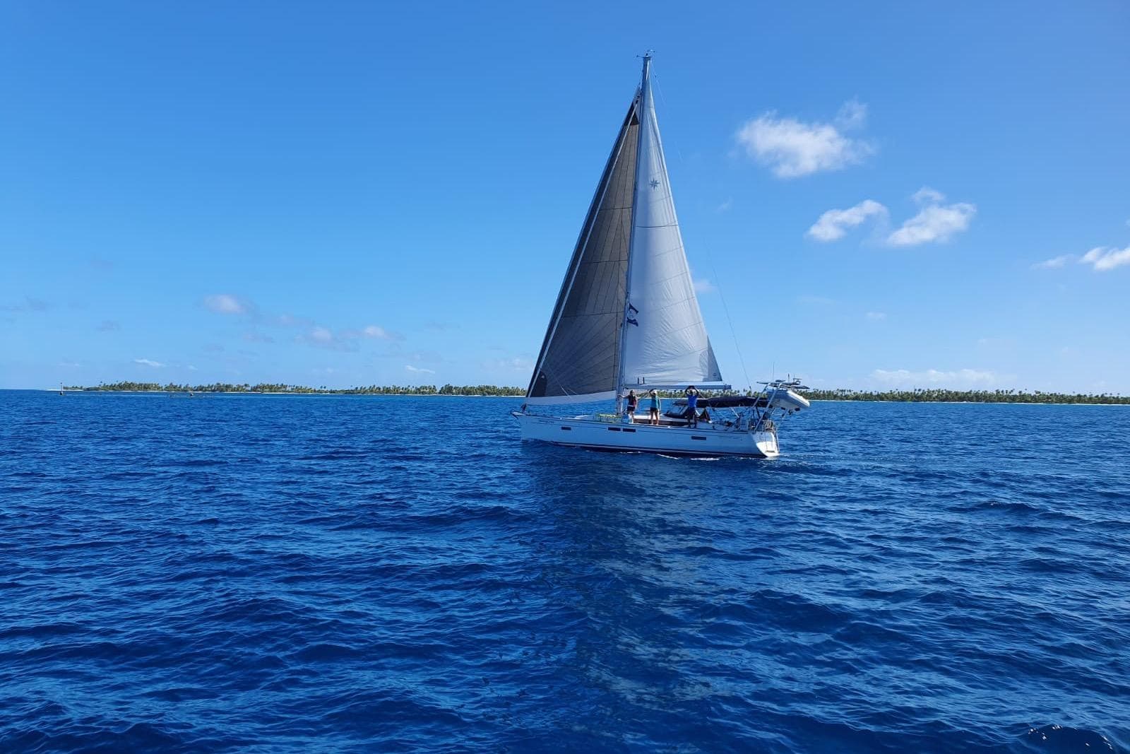 2015 Jeanneau Sun Odyssey 469 sailing on open blue ocean under clear sky.