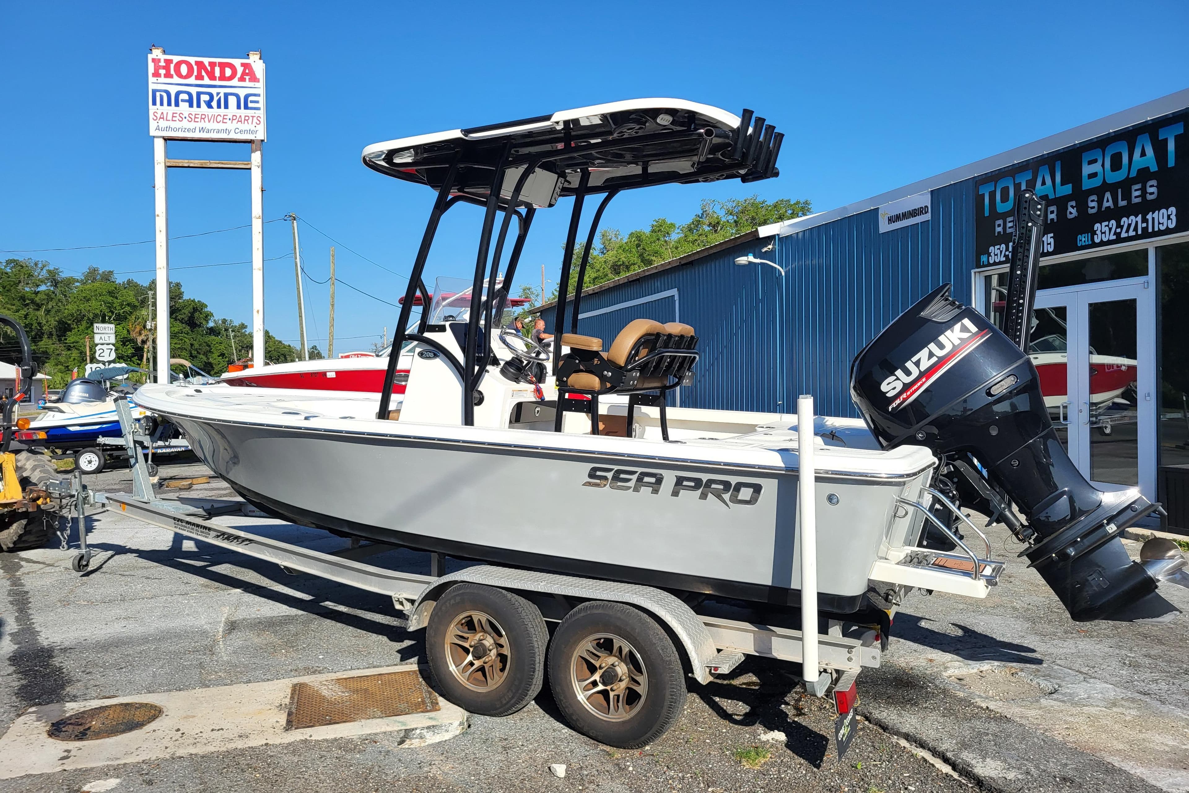 2019 Sea Pro 208 Bay boat on trailer, featuring Suzuki outboard motor, at marine dealership.