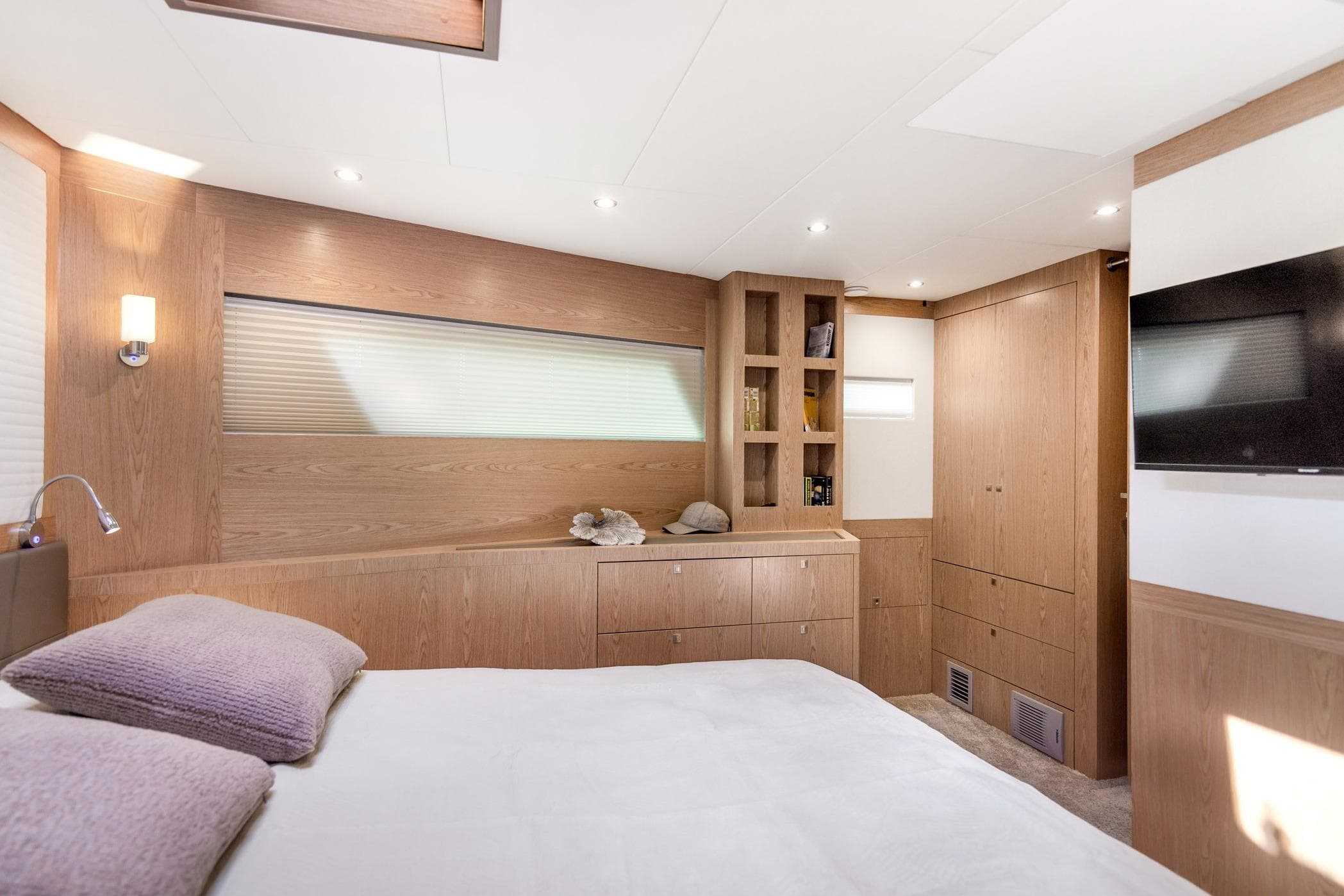 Luxurious bedroom interior of 2026 Cormorant Yachts COR55 RAV, featuring modern wood finishes.
