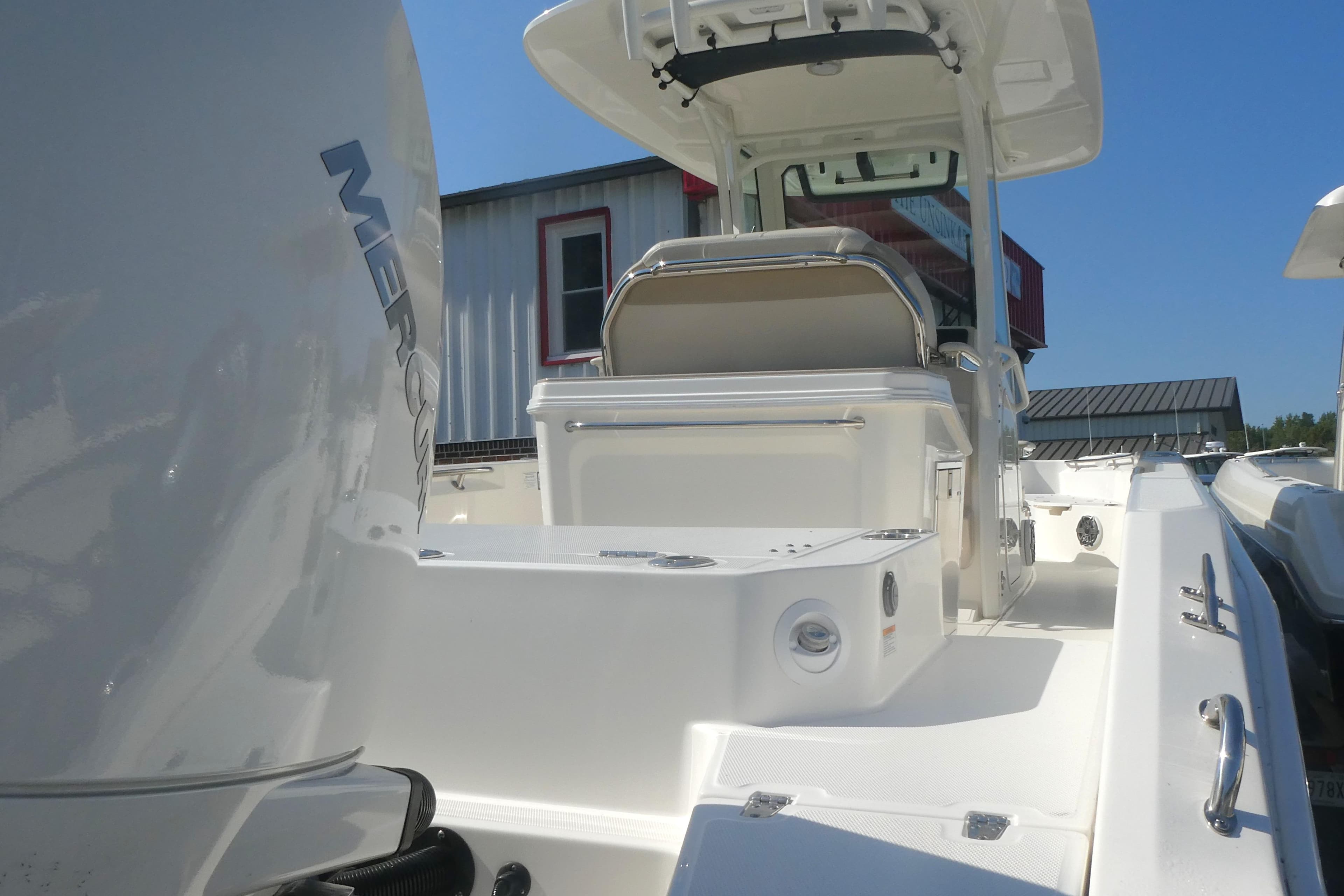 2023 Boston Whaler 280 Dauntless boat with Mercury engine, docked under clear blue sky.