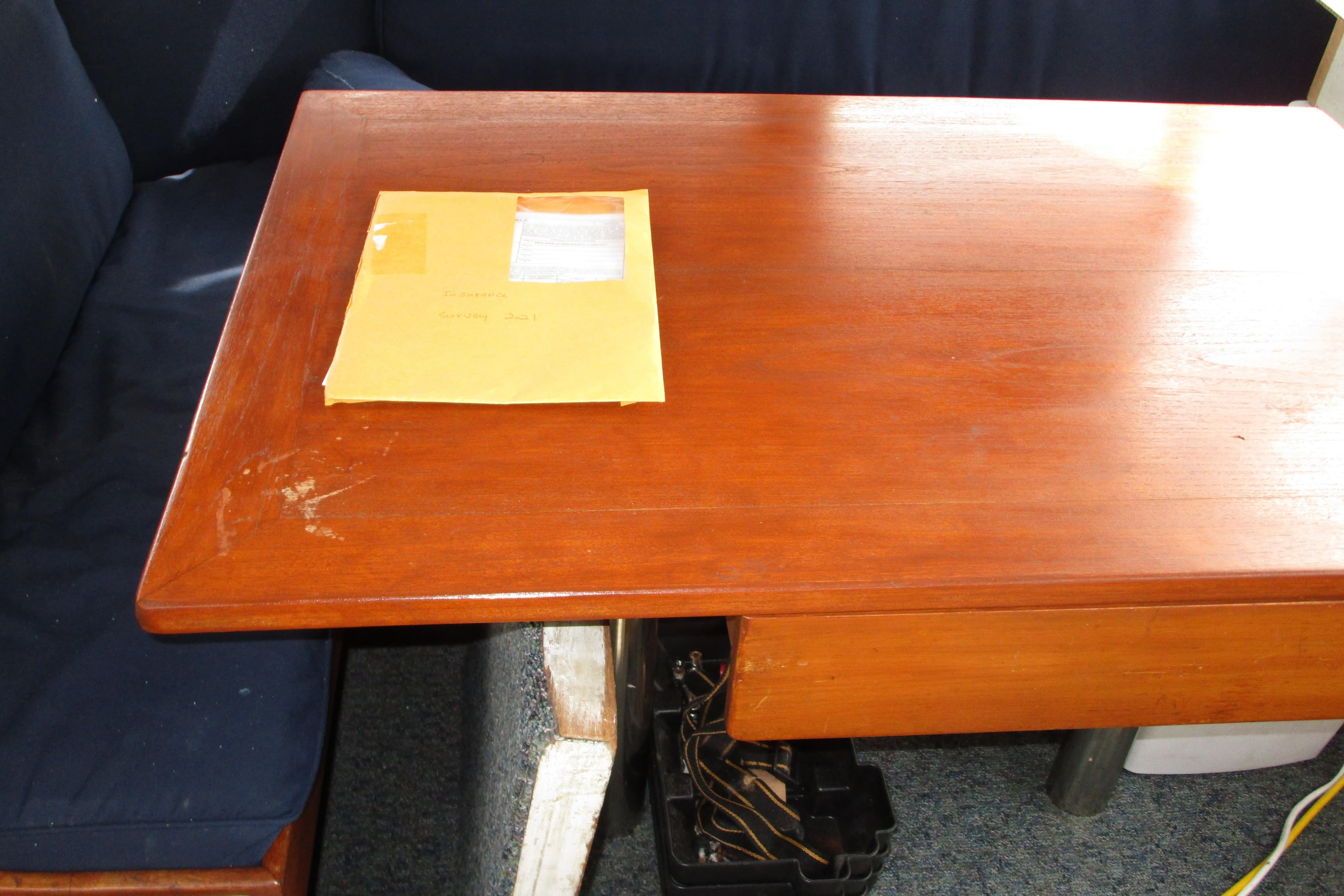 Wooden table with an envelope on a Roughwater 41, 1979 model boat interior.