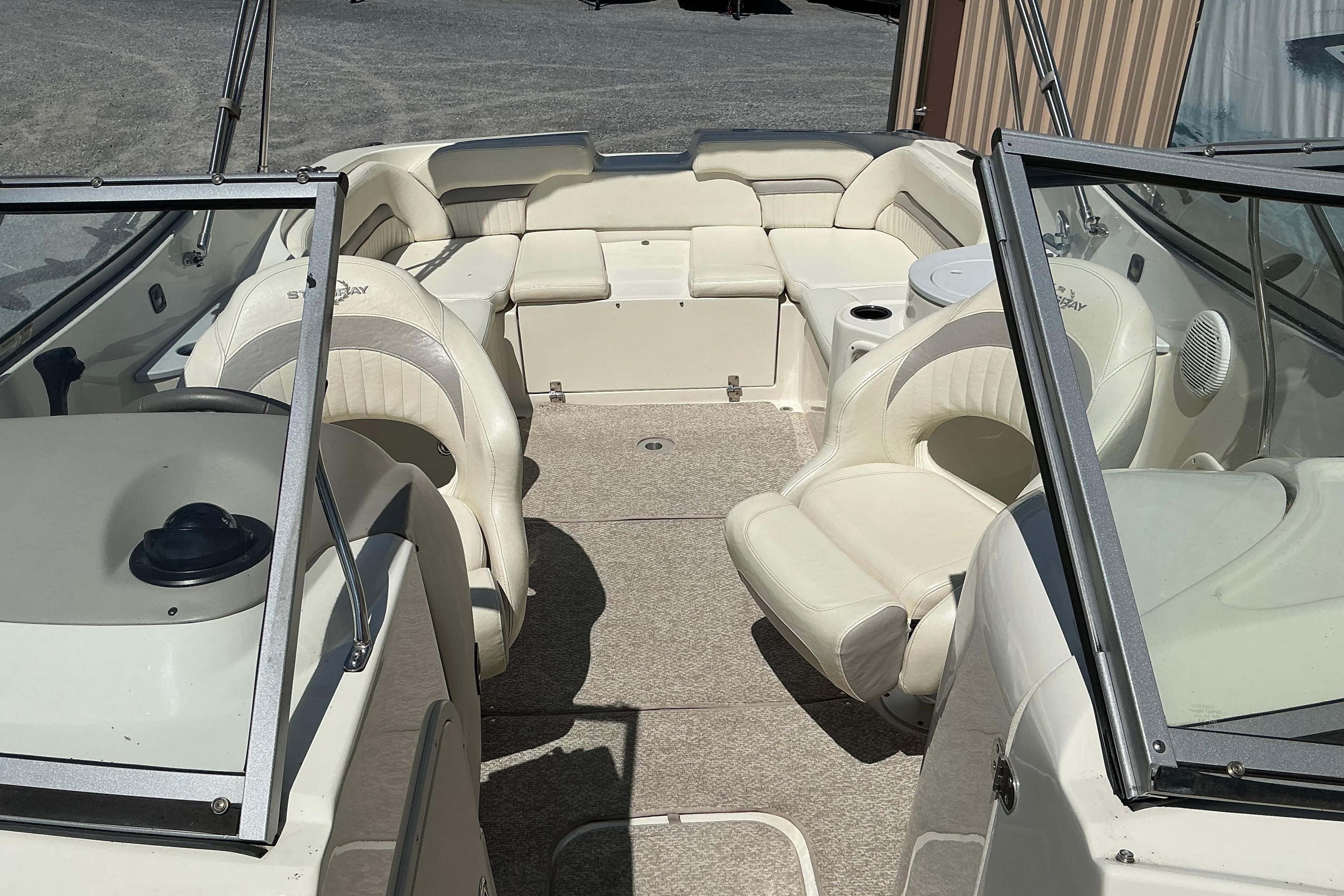 Interior view of a 2010 Stingray 250 LR boat with beige seating and carpet.
