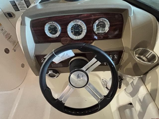 Steering wheel and dashboard of 2013 Sea Ray 220 Sundeck boat.