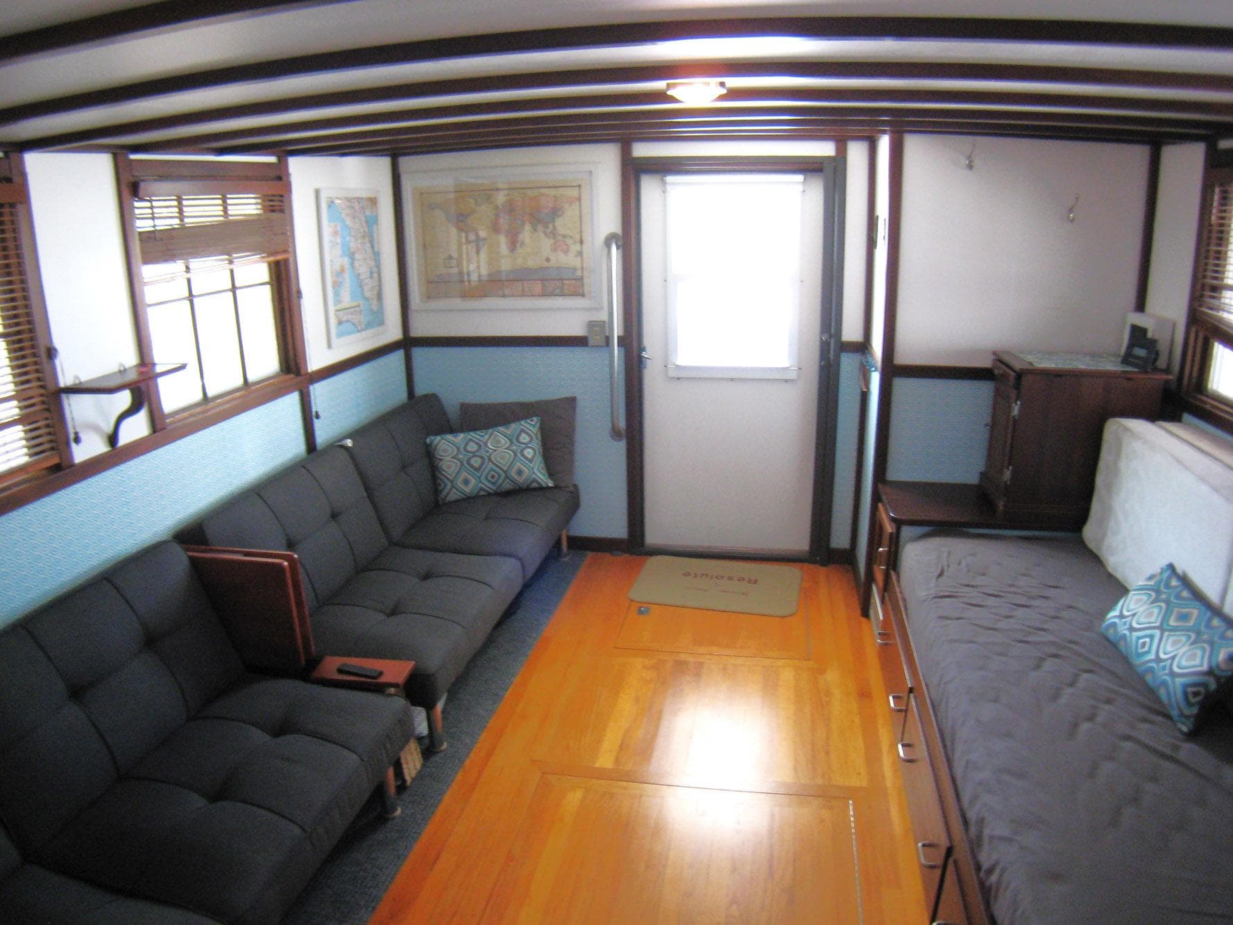 Interior of 1987 Custom Pilgrim Tribute boat with cozy seating and wooden flooring.