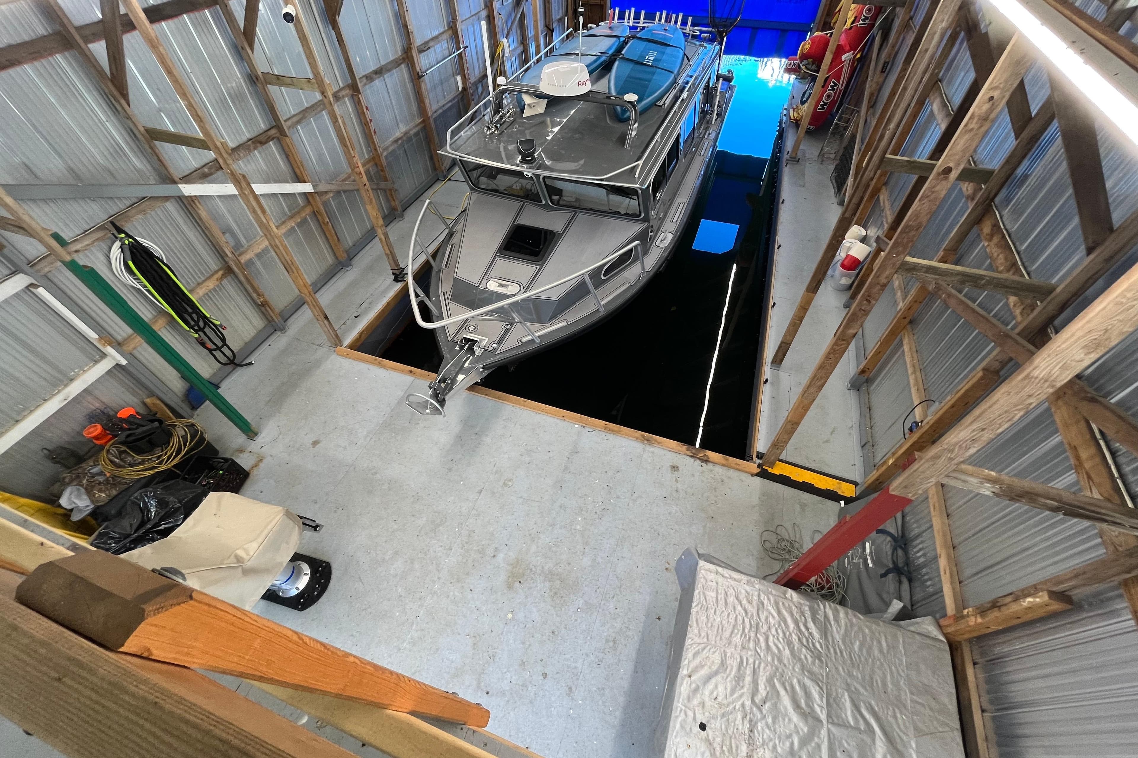 Custom Boathouse 50’ X 20’ with boat docked inside, 2023 model, interior view.