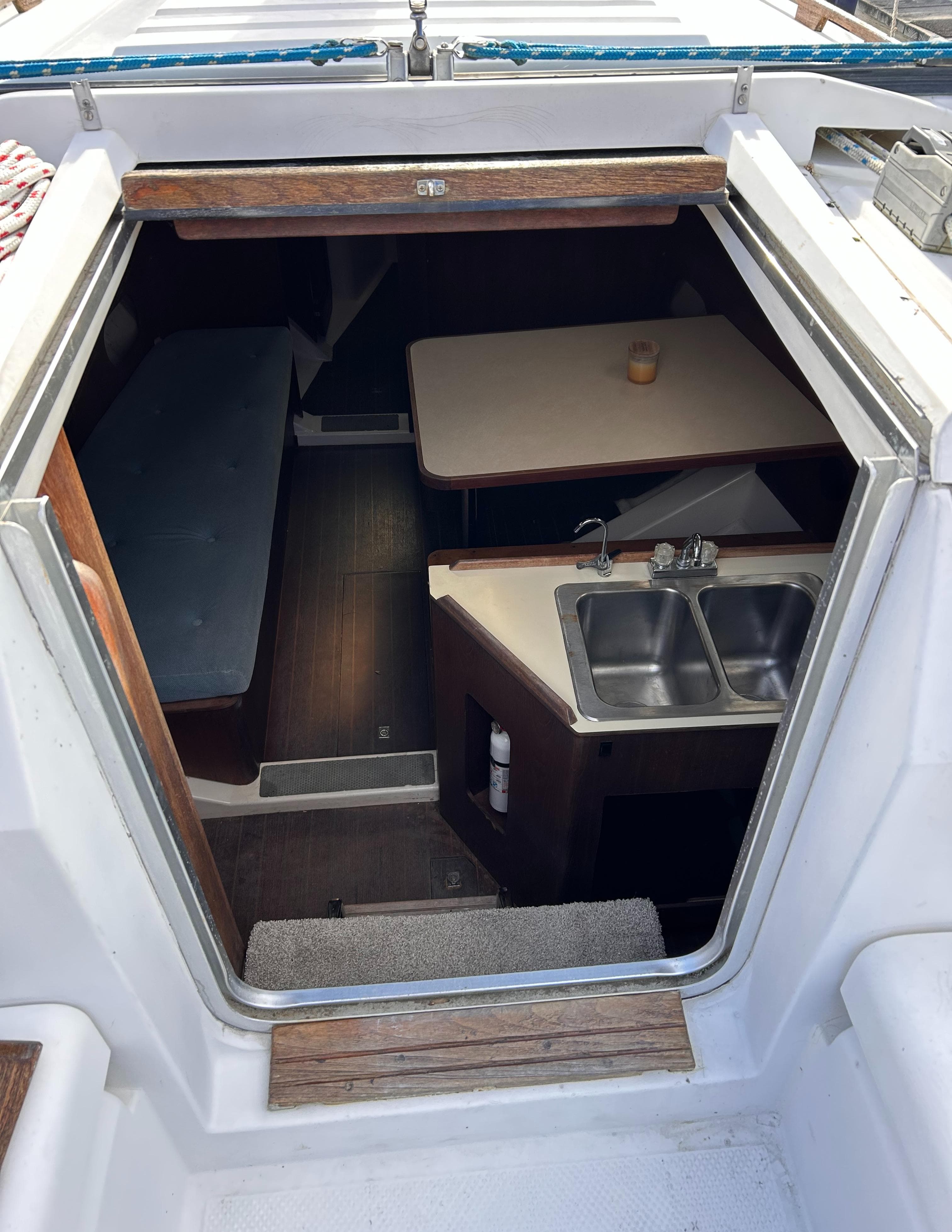 Interior view of 1983 Hunter 34 sailboat, featuring a compact kitchen and dining area.