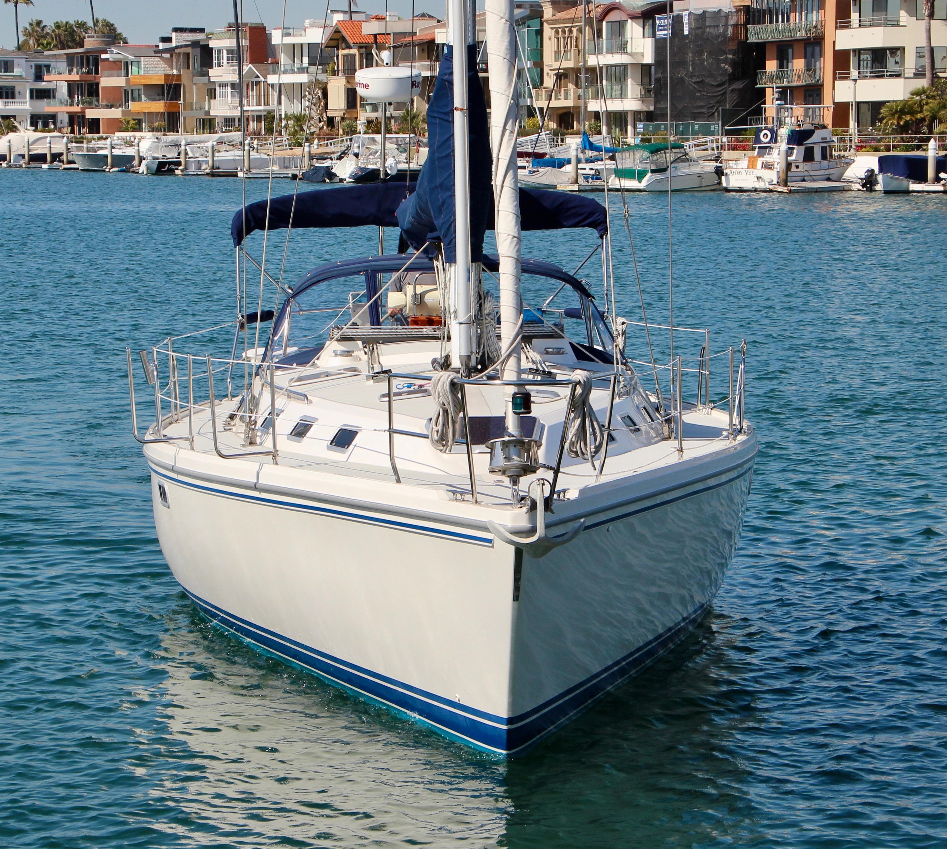 1993 Catalina 42 MKI sailboat docked in a marina, surrounded by waterfront buildings.